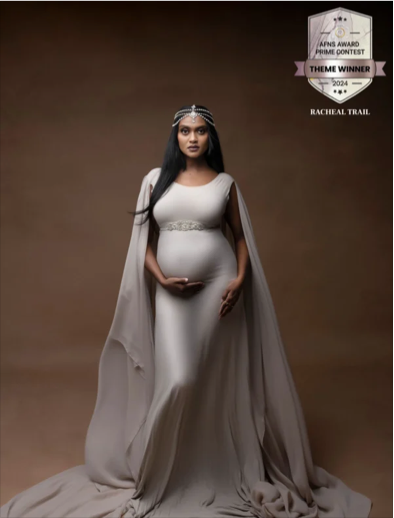 Pregnant woman in a white dress with a cape and jeweled headband, posing against a brown background. There is a logo in the top right indicating she is the theme winner of the 2024 AFNS Award Prime Contest, Rachel Trail.