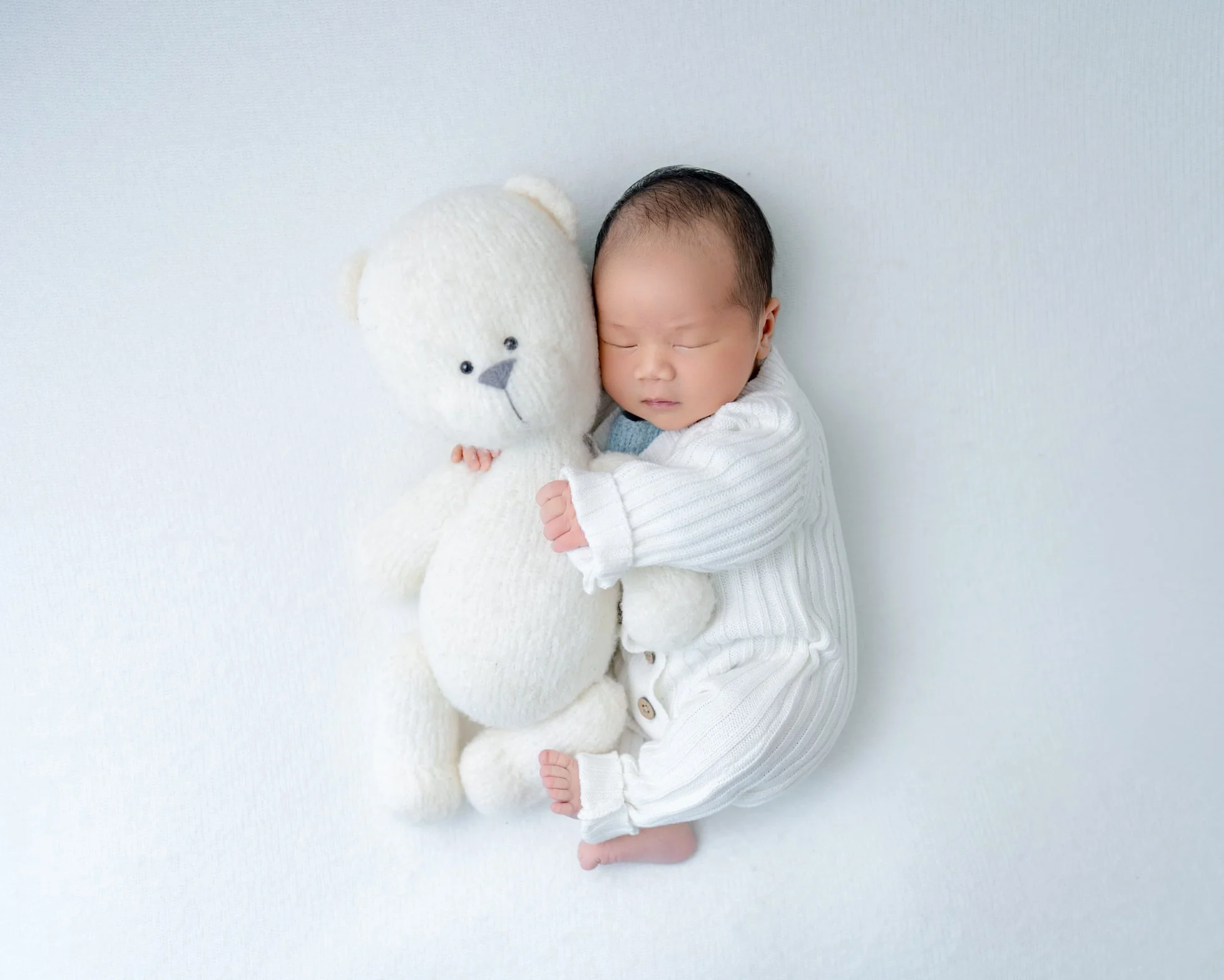 Cute sleeping baby boy safely posed during a West Auckland in-home photography session.