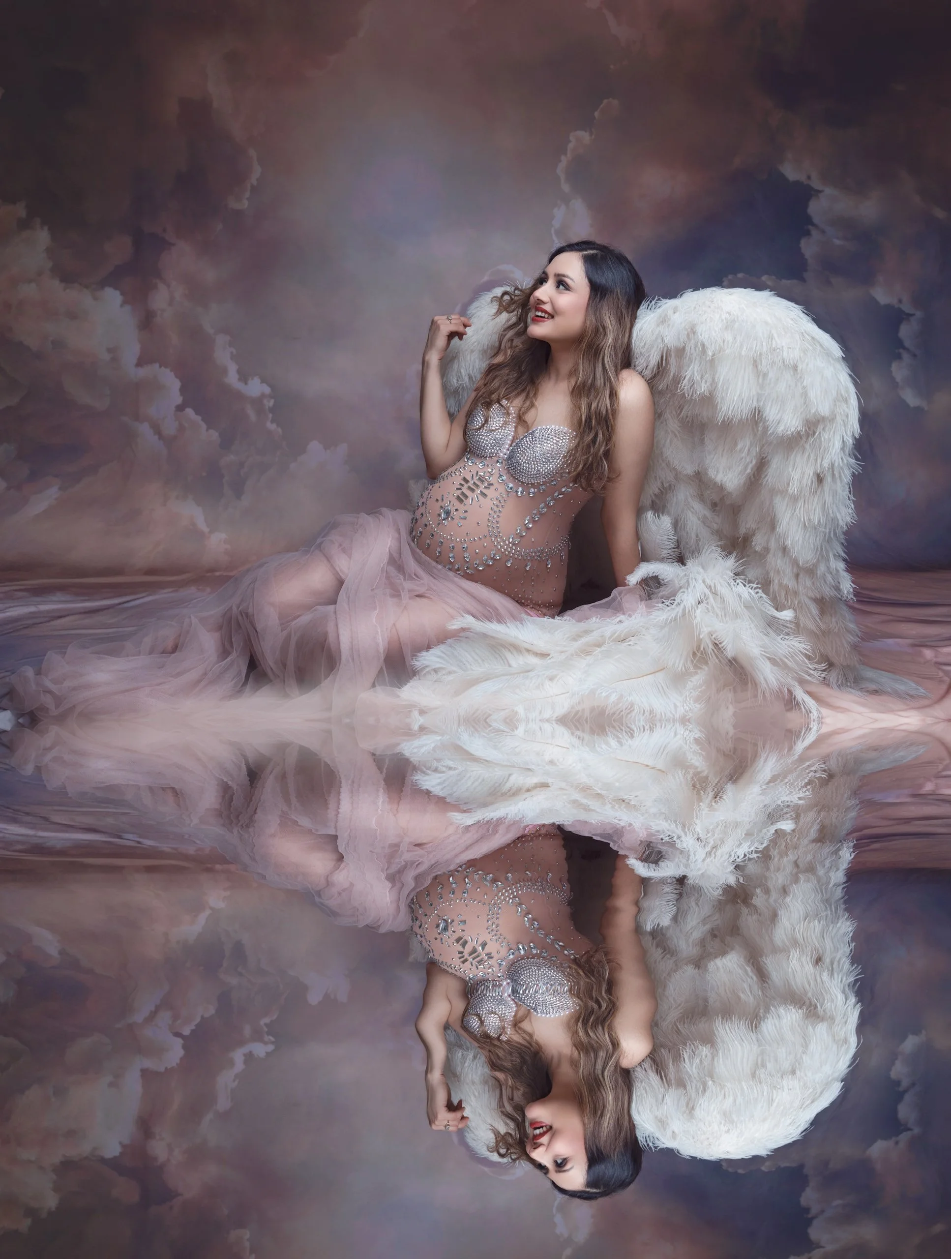 Pregnant woman wearing angel wings during a creative maternity photography session in Auckland.