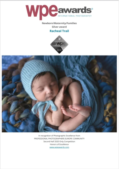 An award certificate from the WPE Awards for photography in the newborn/maternity/families category, featuring a sleeping baby with a blue knitted hat and blanket.