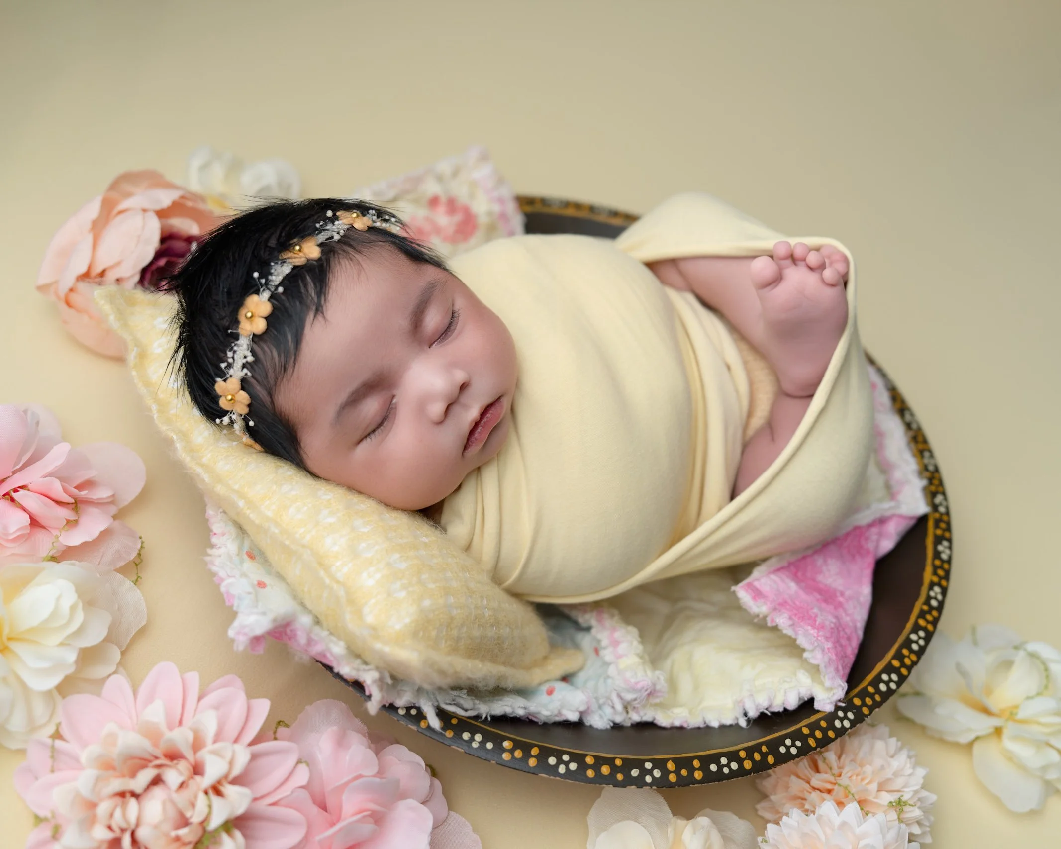 Newborn baby wrapped in yellow during a posed newborn photography session in Auckland