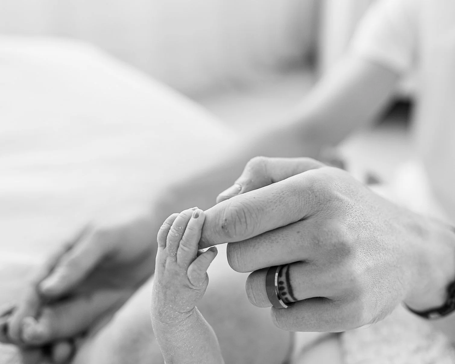 Newborn baby holding a parent’s finger during a guided lifestyle newborn session in Auckland