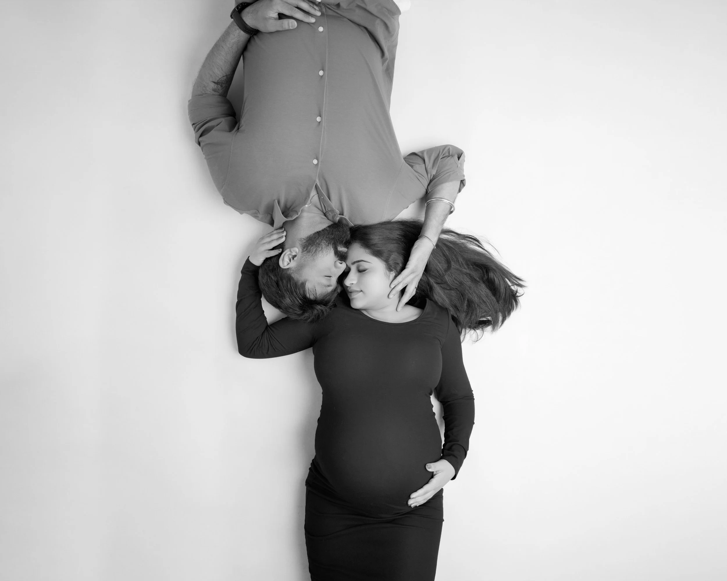 Black and white maternity portrait of an expecting couple together in South Auckland studio, photographed by Racheal Trail Photography.