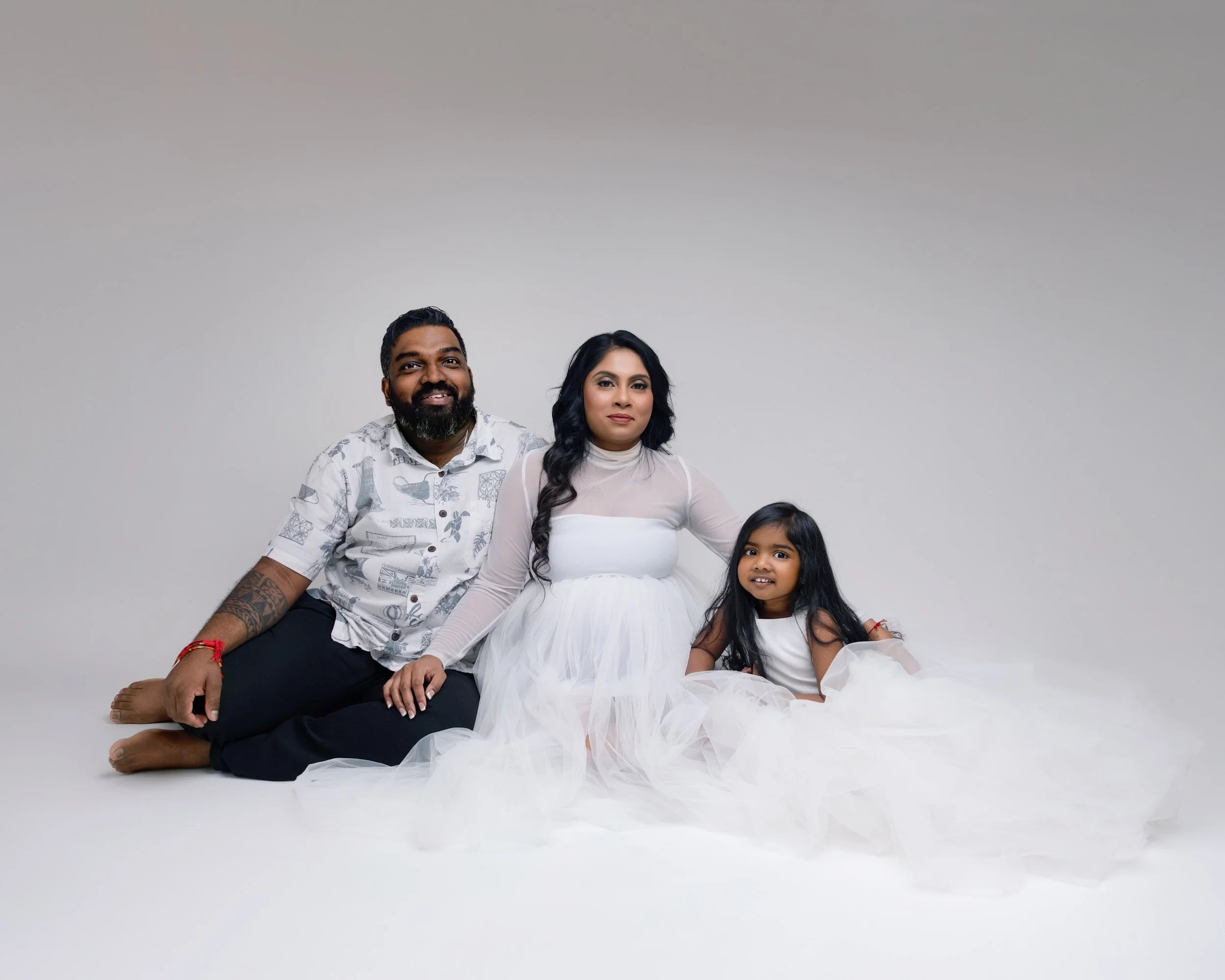 Expecting parents with their daughter during a family maternity photography session in Auckland.