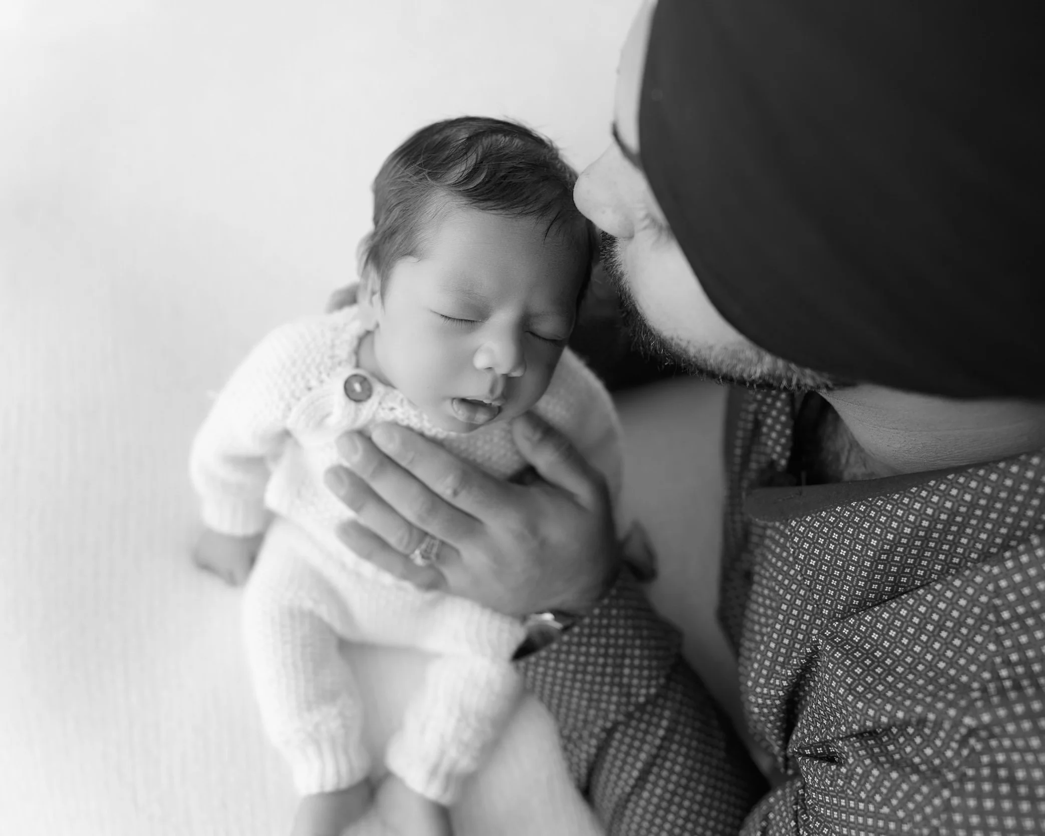 Close-up of a father holding his sleeping newborn baby during a guided lifestyle photography session in Auckland.