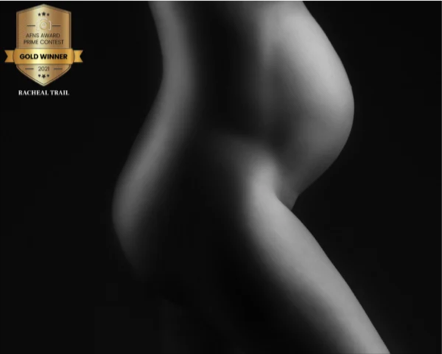 Close-up black and white photograph of a person's torso and hips, highlighting curves and skin texture.