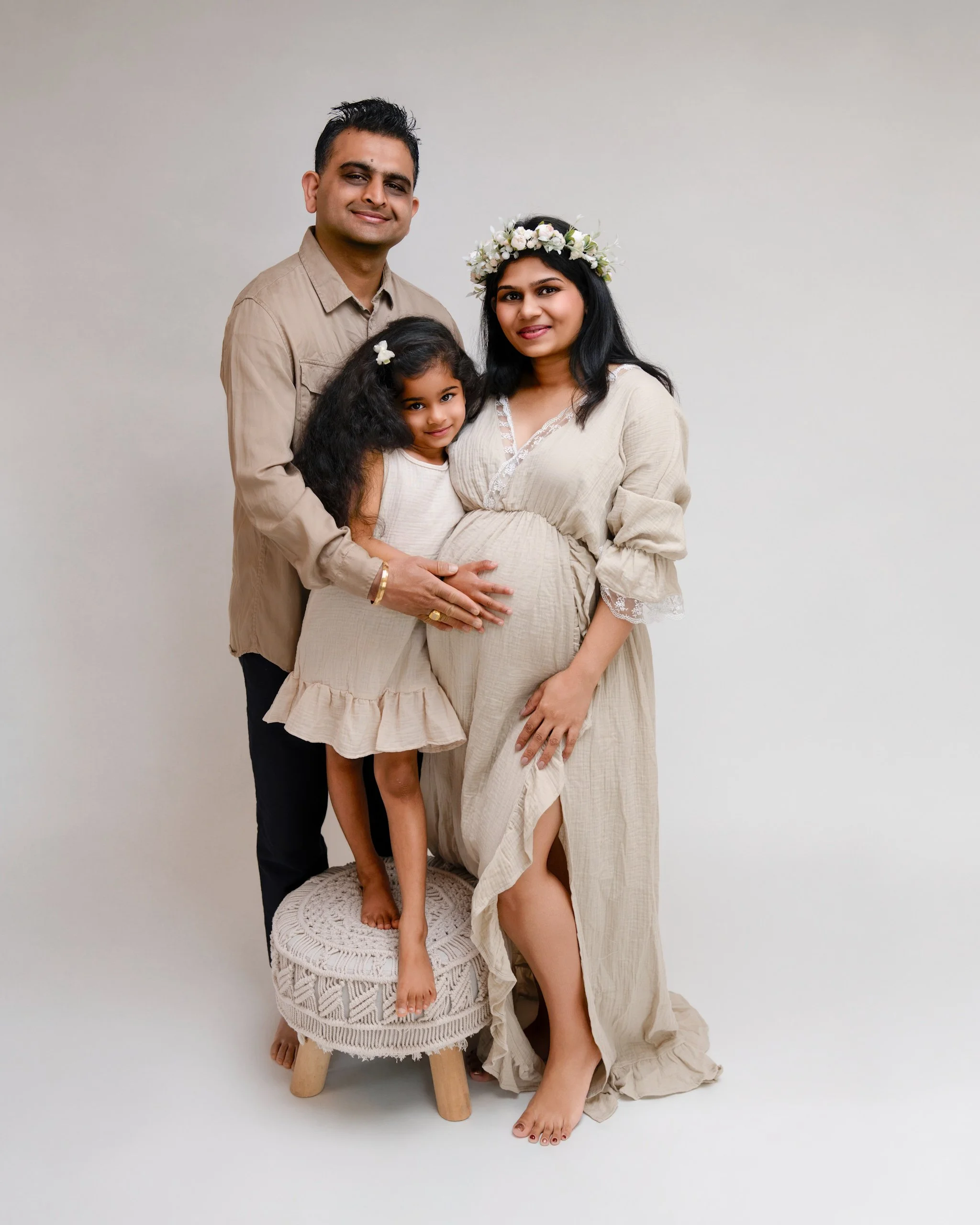 Pregnant mum with partner and daughter during a relaxed Auckland studio maternity photography session.
