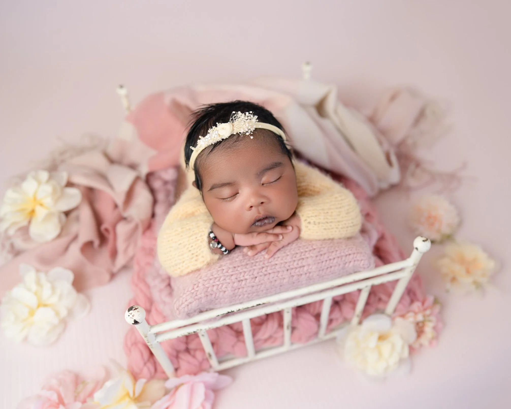 Newborn baby on a bed during a posed newborn photography session in Auckland