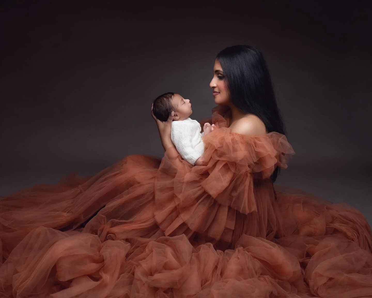 Elegant mother and newborn portrait with flowing rust-coloured gown by award-winning Auckland photographer Racheal Trail