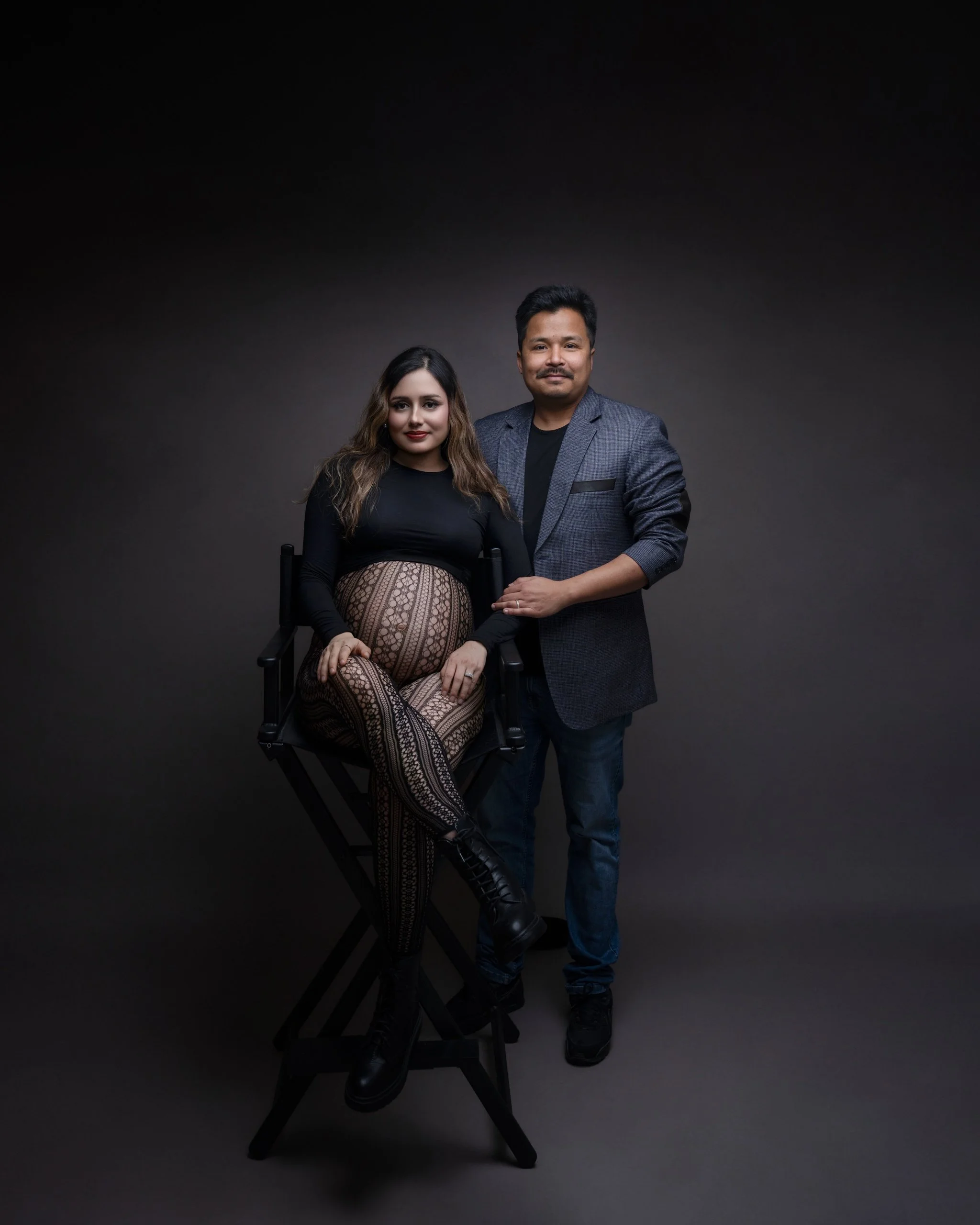 Expectant mum and her husband posing together during their Auckland studio maternity photography session.