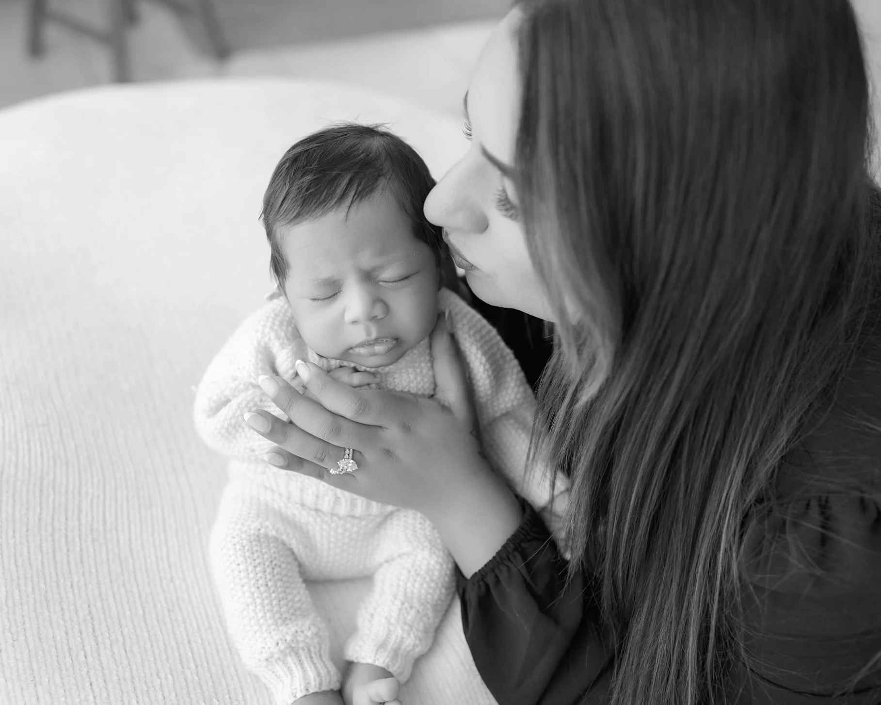 Mum cuddling her newborn baby during a soft and natural guided lifestyle newborn session in Auckland.