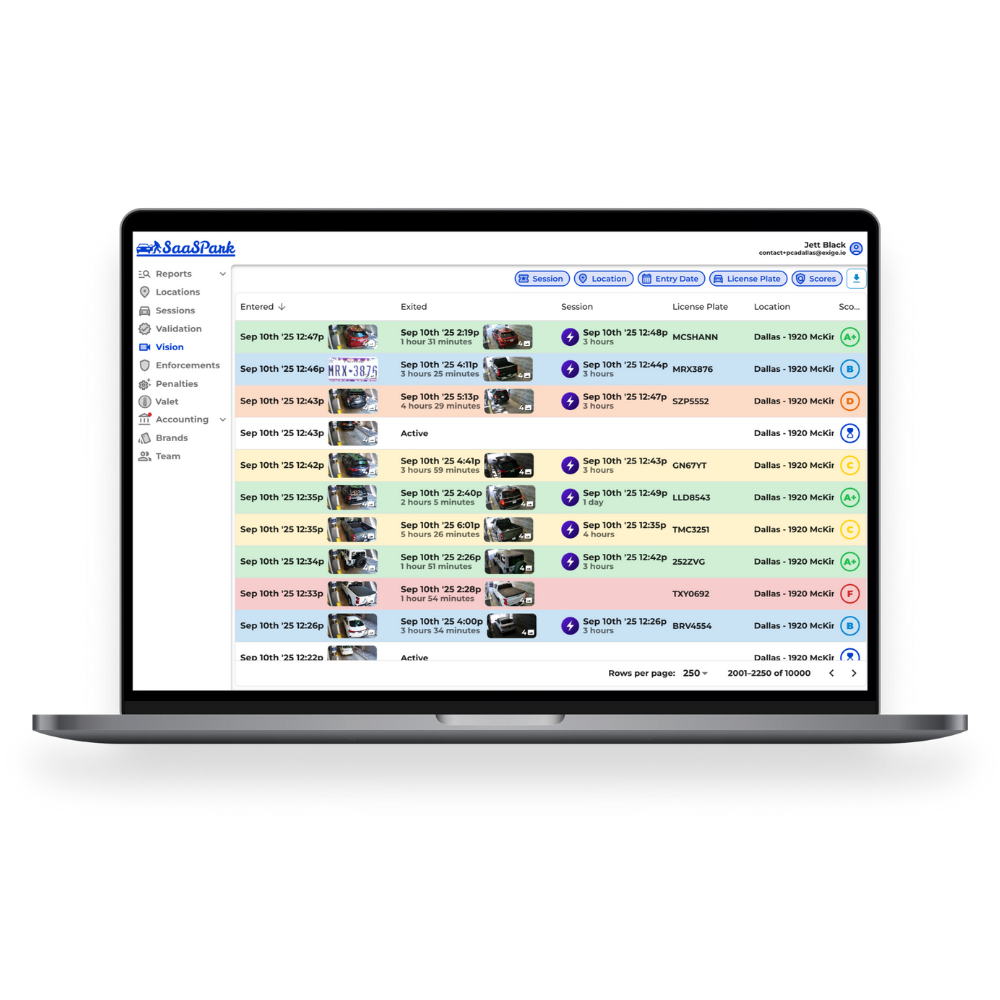 Laptop displaying a vehicle management dashboard with rows of vehicle data, statuses, timestamps, and color-coded alerts.