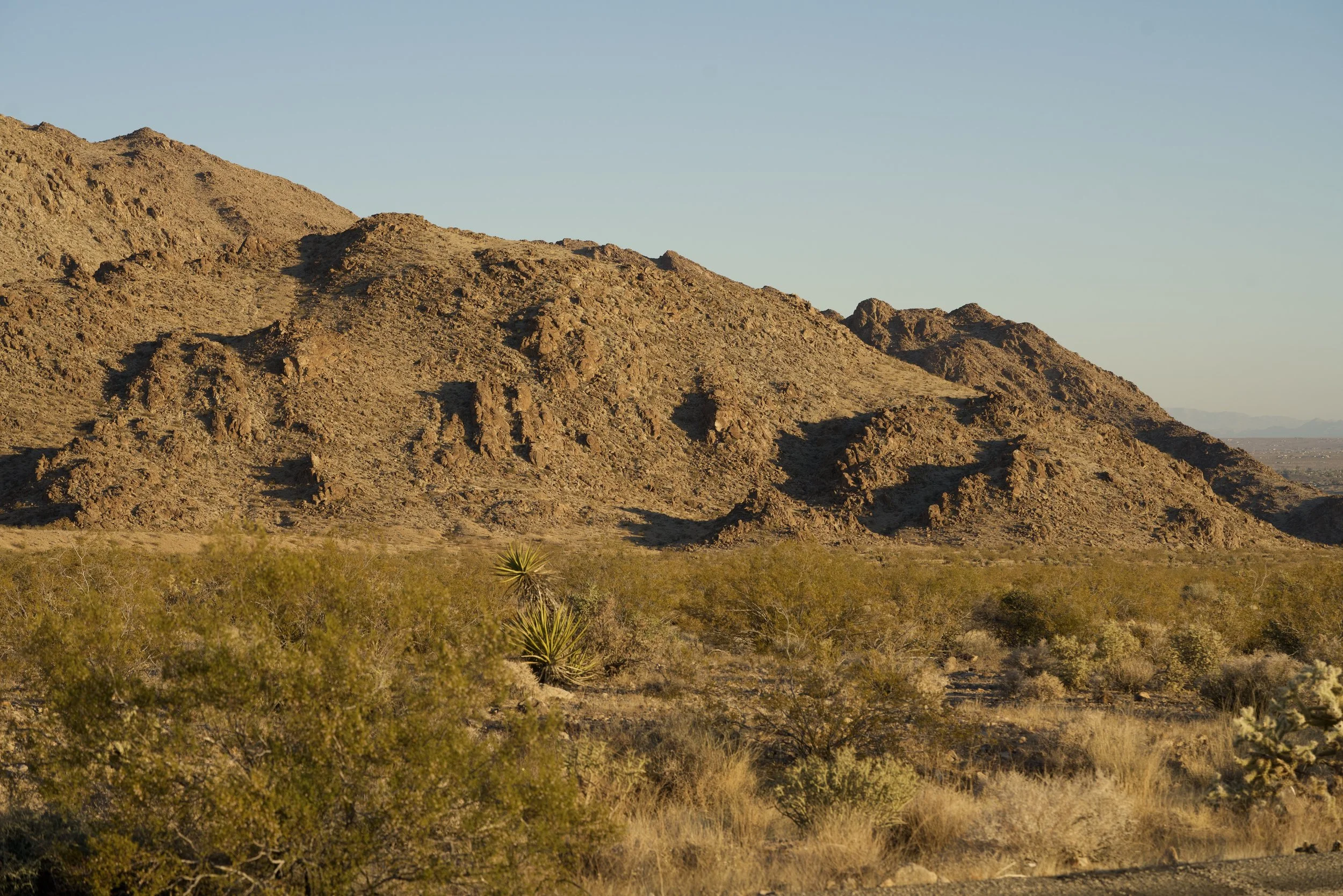 Mountain landscape near the Shadow Wash Pavilion site in Twentynine Palms, California, showcasing the rugged Mojave Desert terrain that inspired the project’s architecture and material palette.
