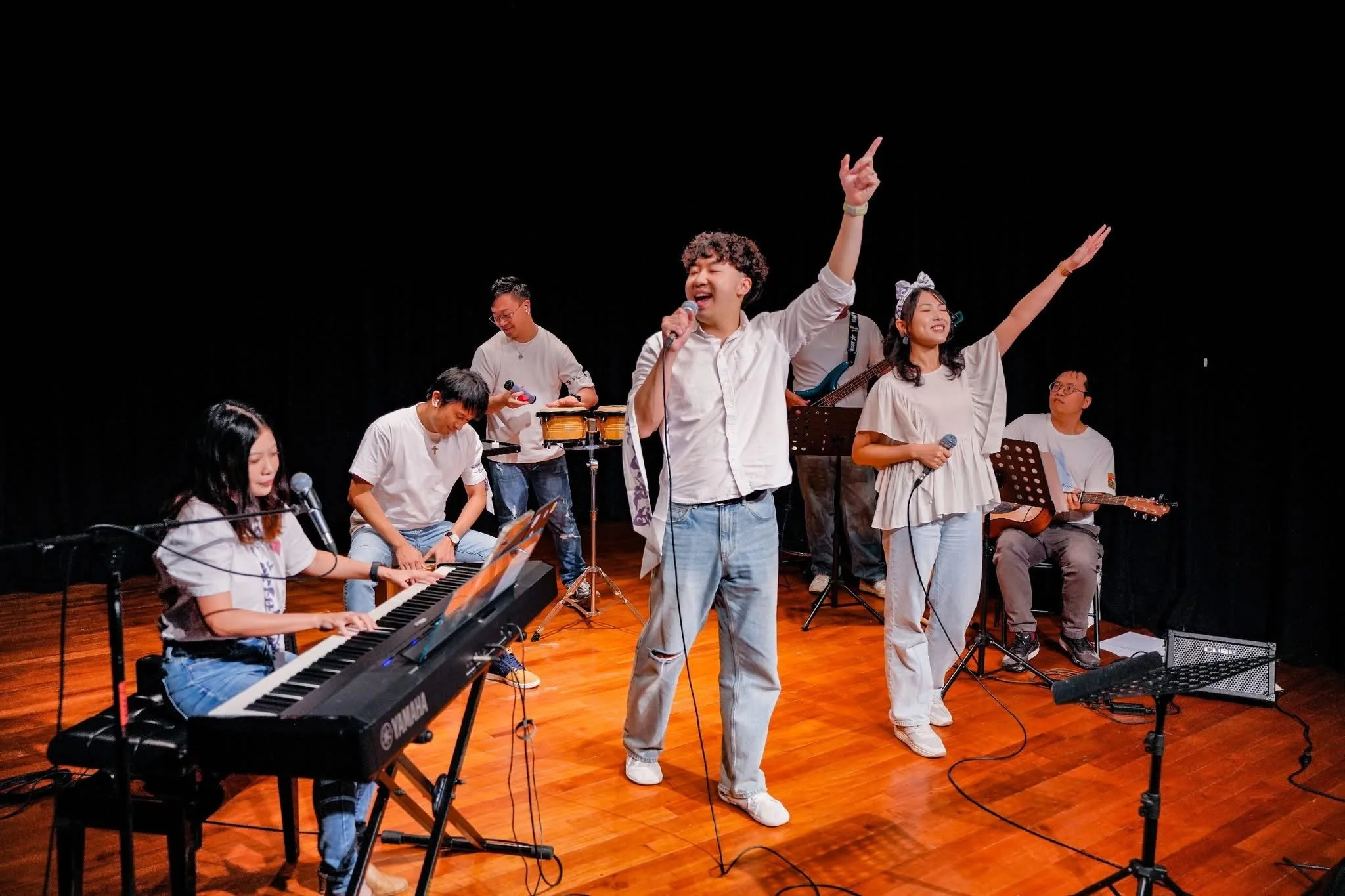 An energetic band playing on a wooden stage.