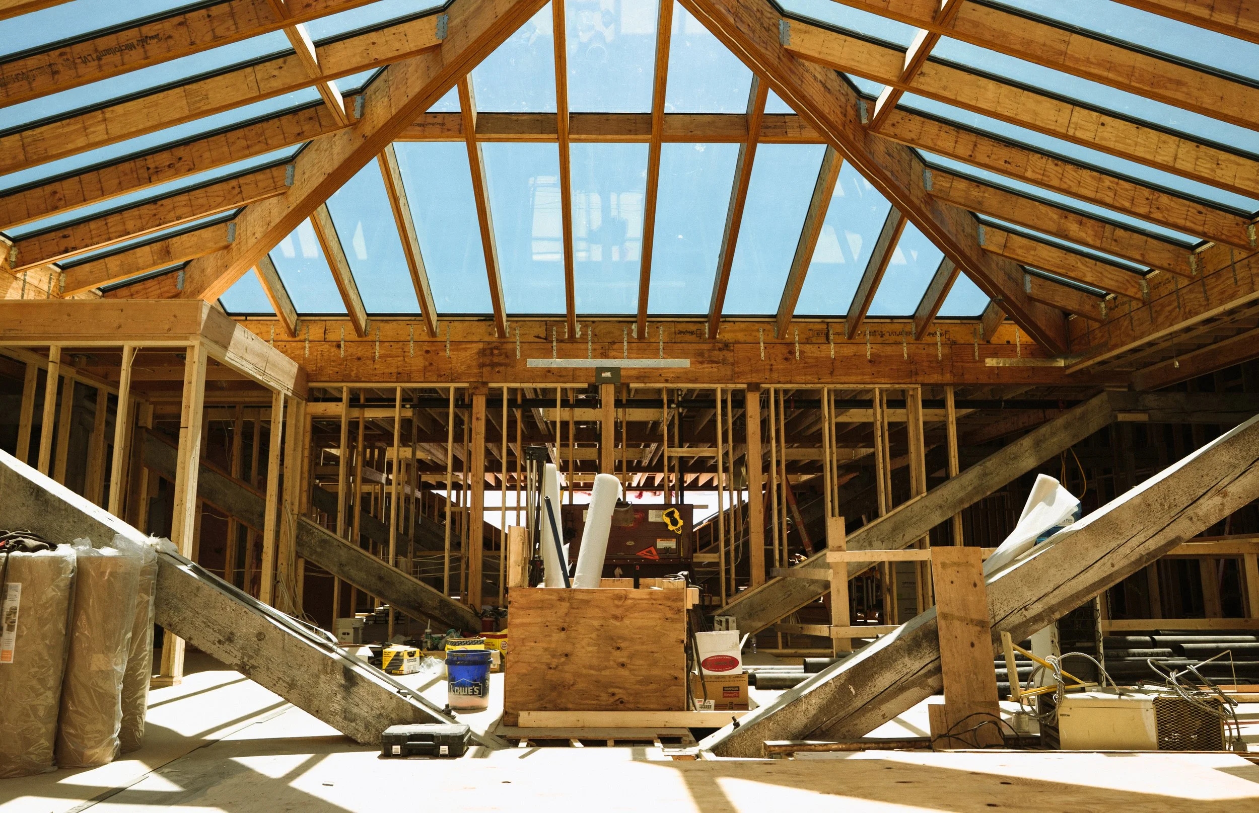 Construction site with wooden framing and a large skylight ceiling.