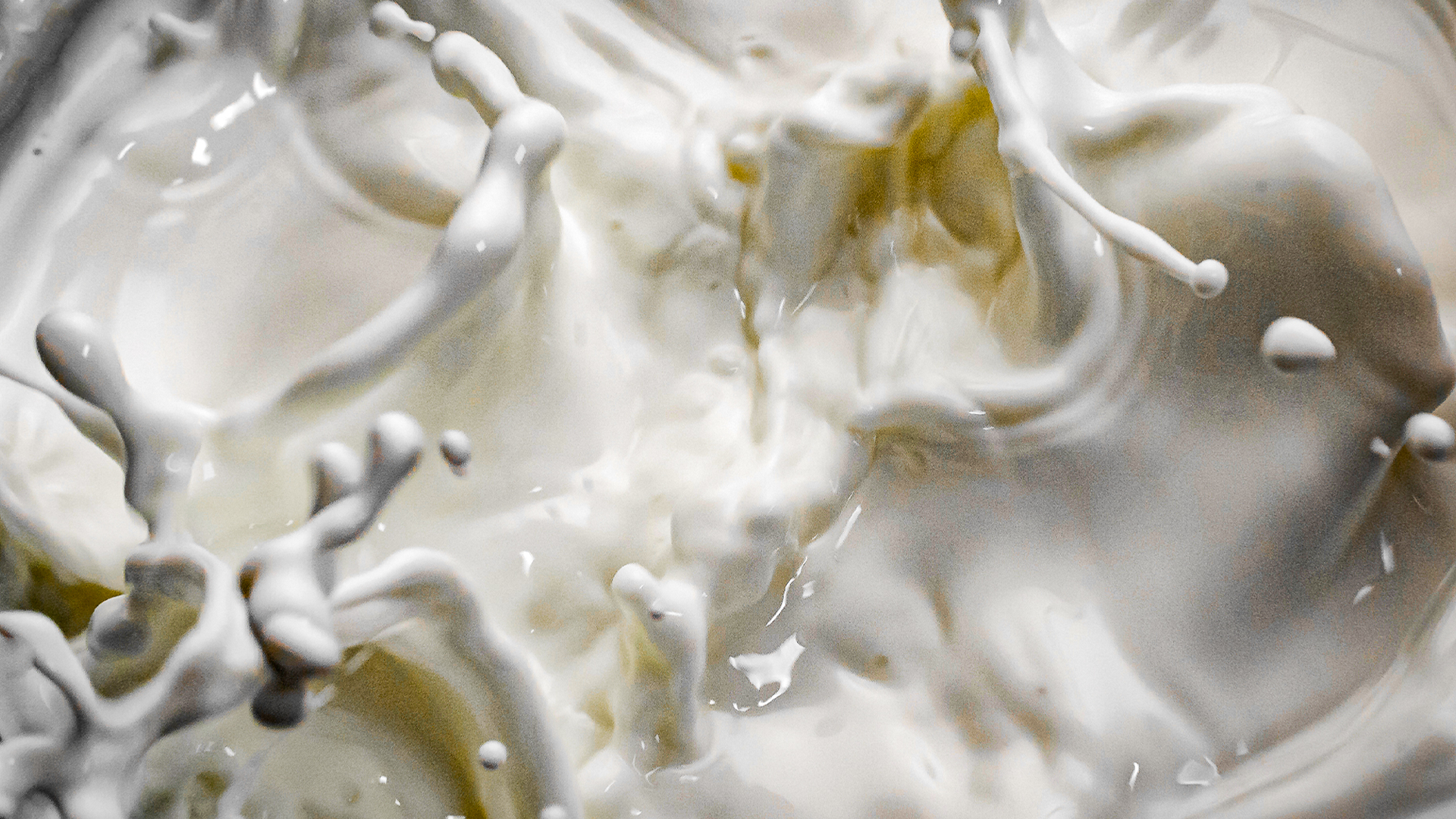 Leite sendo agitado, criando espumas e gotas ao redor