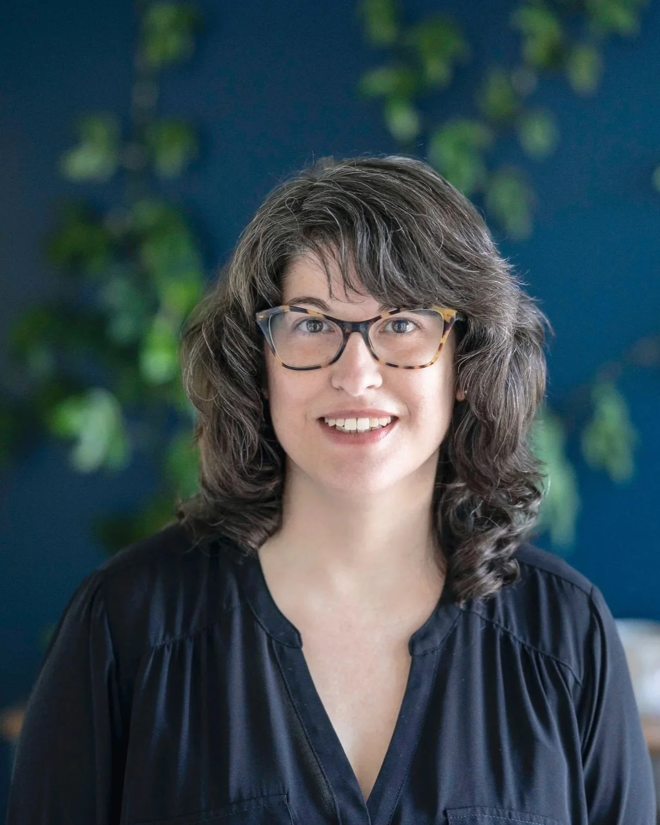 Headshot of woman with brown hair and black shirt