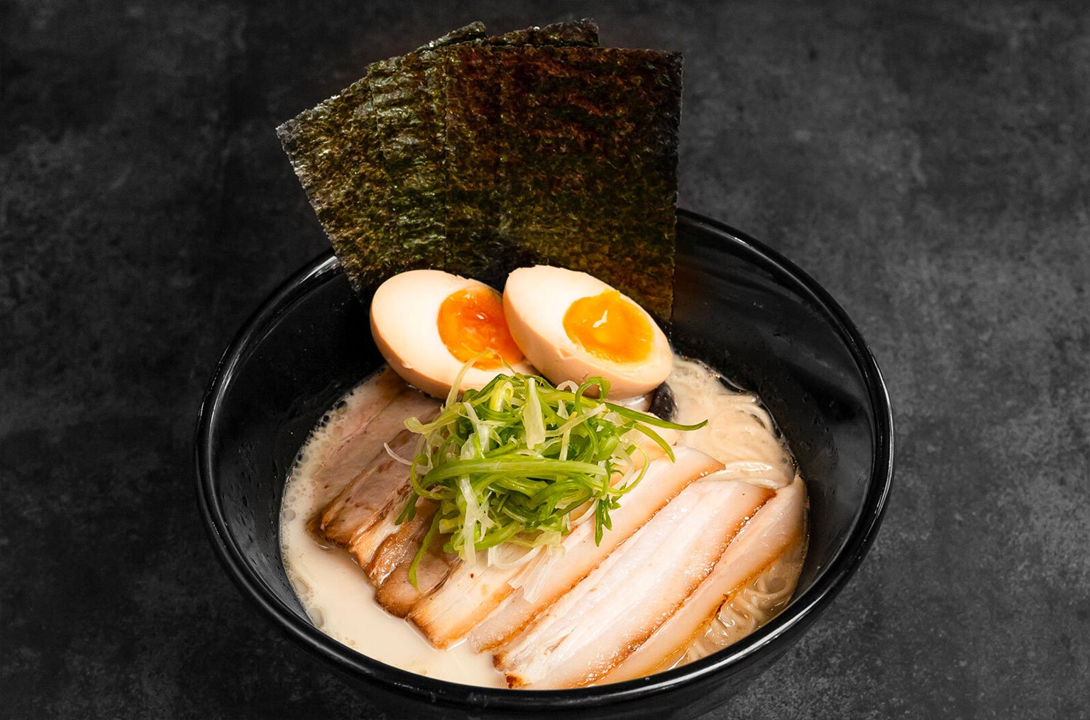 The works! Tonkotsu Ramen served with seasoned egg, generous portions of thinly sliced chashu, and three pieces of seaweed