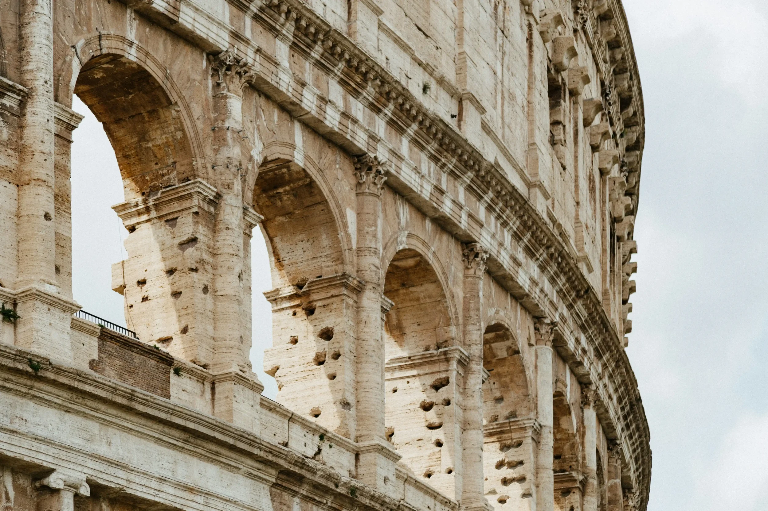 A close-up, detailed view of the ancient stone arches of the Colosseum in Rome, representing the Urban Deep Dives cultural city itineraries on Swallow's Notes.