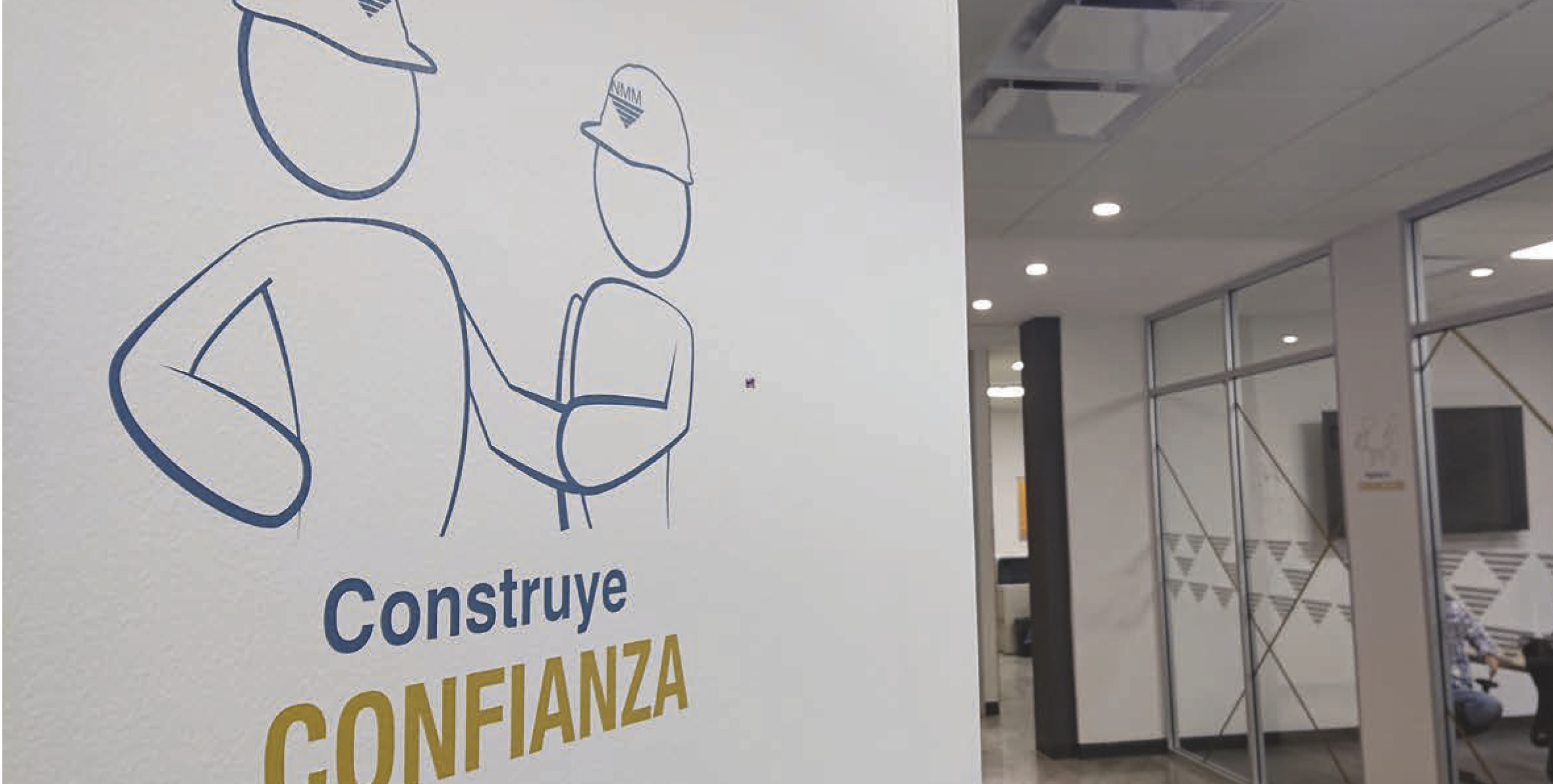 Sign with line art of two figures wearing helmets holding hands, with the Spanish text 'Construye Confianza'.