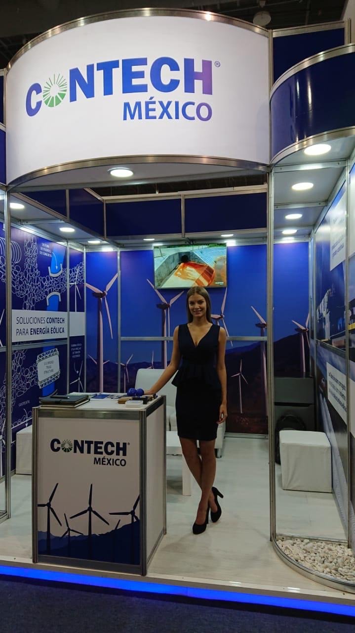 Exhibit booth for CONTECH Mexico with wind turbines and a woman in a black dress standing inside