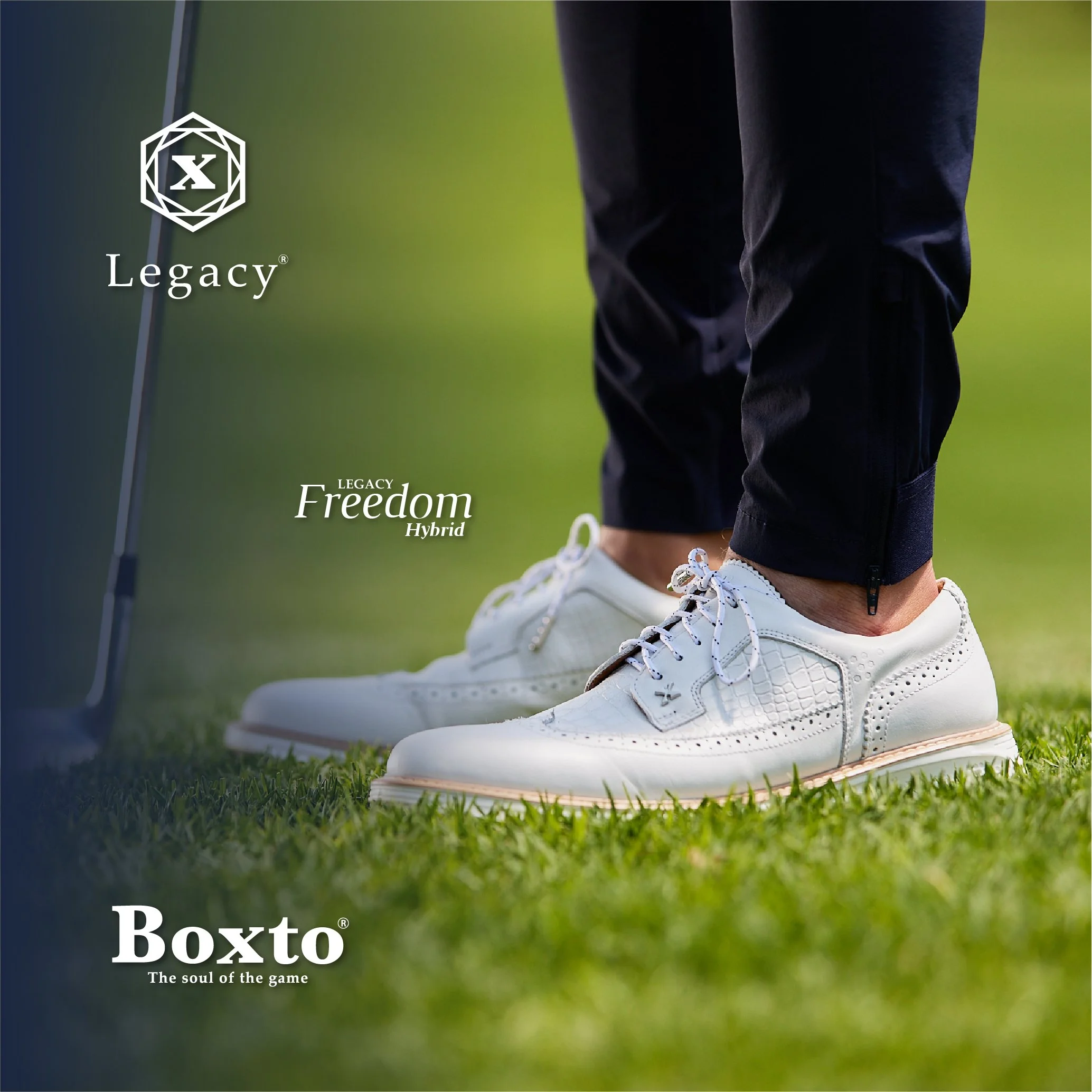 Close-up of a person wearing white golf shoes with intricate detailing on a grass golf course, holding a golf club, with black pants. The image includes the Legacy logo, and text mentioning Legacy Freedom Hybrid and Boxto, along with their slogans.
