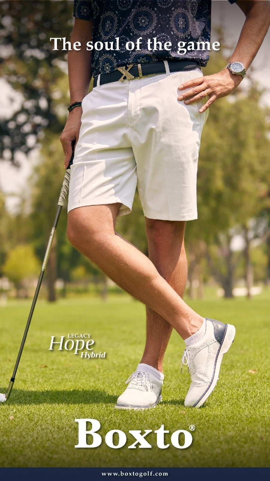 Close-up of a man standing on a golf course, holding a golf club in one hand, wearing golf shoes, white shorts, a dark patterned shirt, and a watch, with text overlay promoting the Boxto golf product.