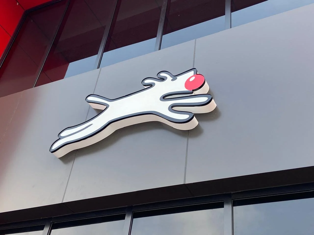 Sign of the clothing company Puma featuring a stylized puma cat with a pink nose