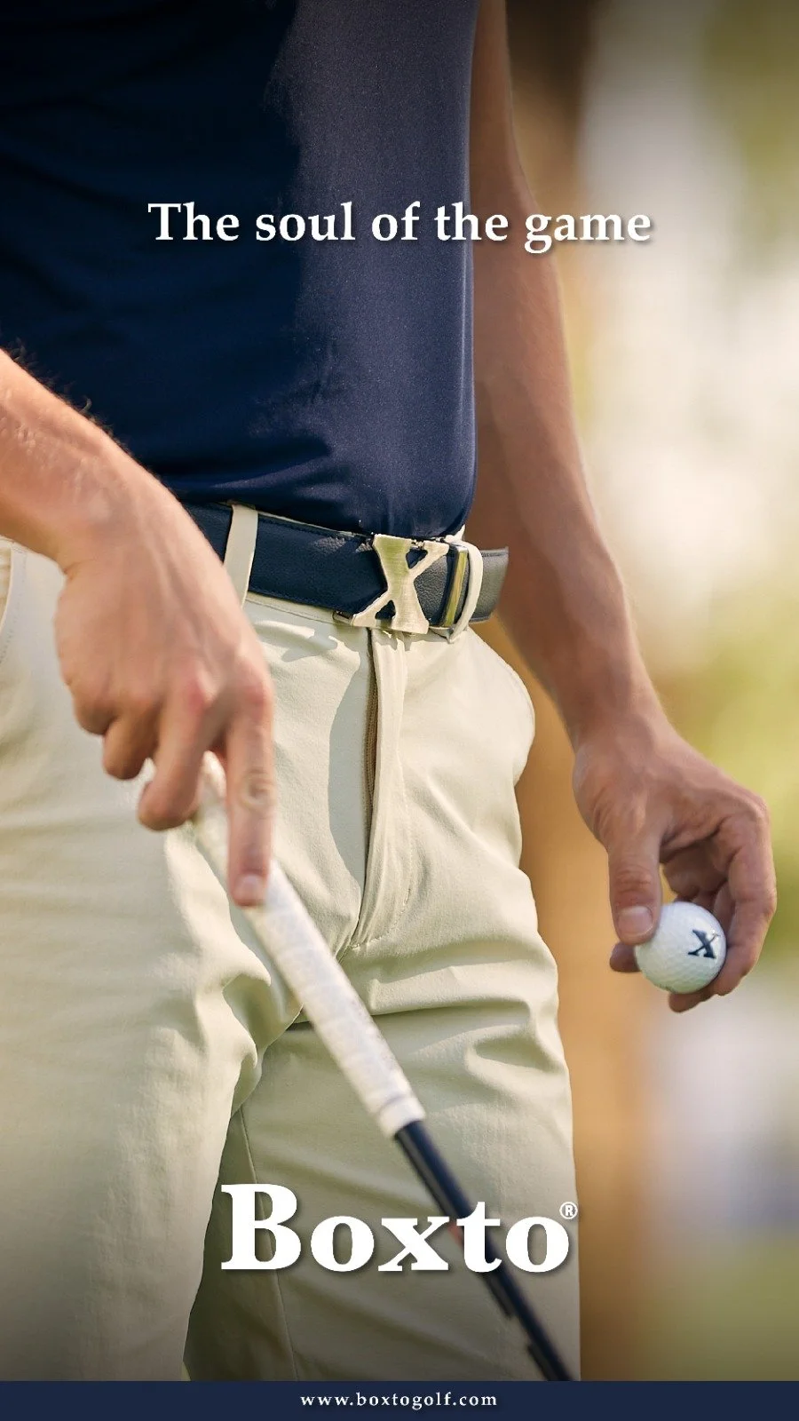 Close-up of a golfer holding a golf ball in one hand and a golf club in the other, with the text 'The soul of the game' and 'B0xt0' overlaid.