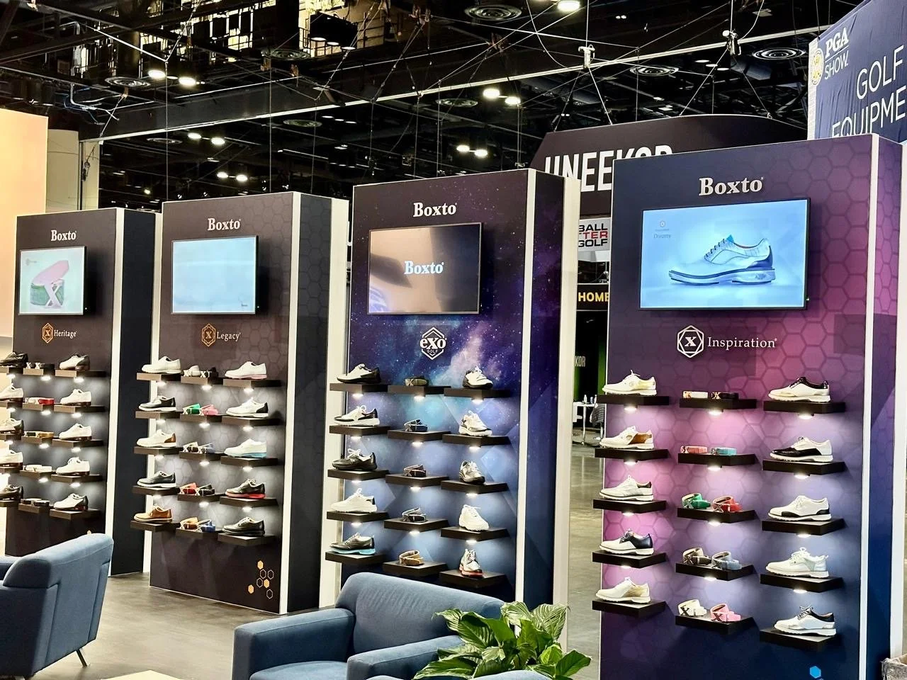 Display shelves with athletic shoes at a booth, featuring brands like Boxto with various shoe models arranged on illuminated black shelves, and digital screens above each display.