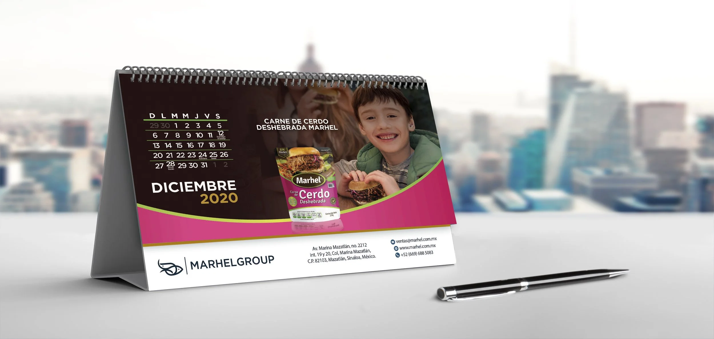 Calendar showing December 2020 with an advertisement for shredded pork meat by Marhel, featuring a smiling boy holding a sandwich, on a desk with a pen, cityscape background.