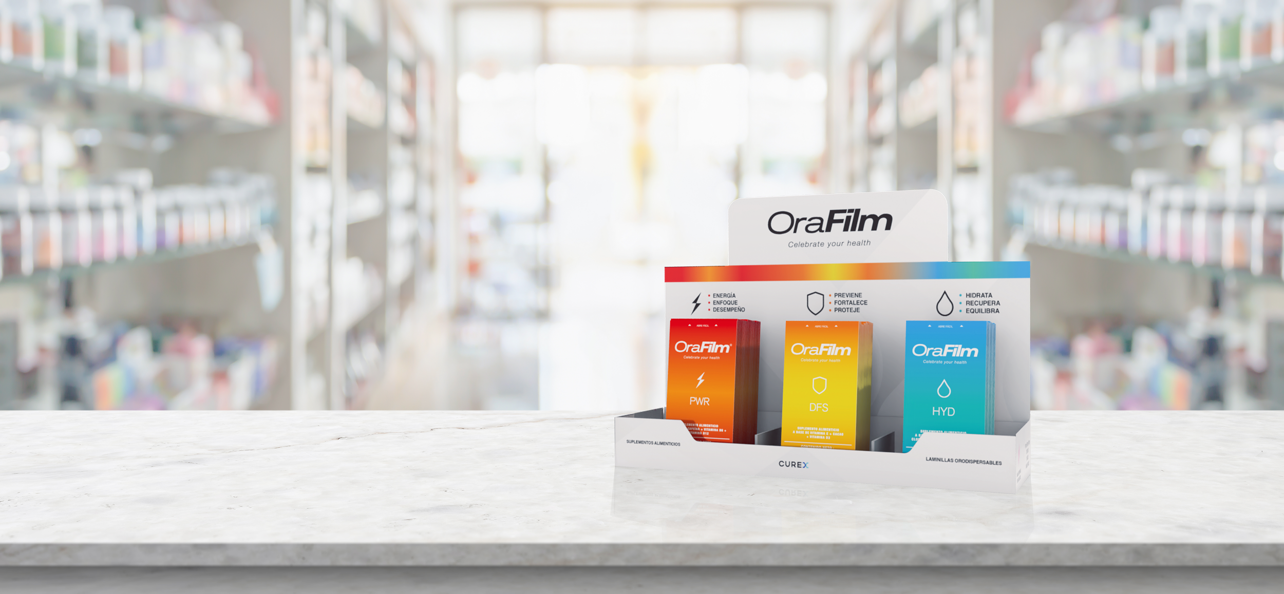 Display stand with OraFilm health supplements on a marble countertop, with blurred pharmacy shelves in the background.