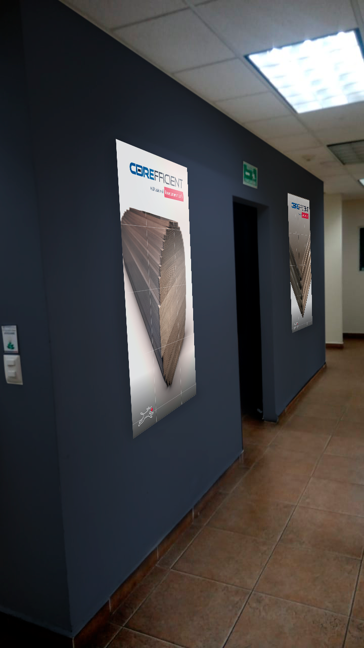 Indoor hallway with dark blue walls, featuring advertisements for Corefact, showing a modern skyscraper building, with a door and an emergency exit sign above it, ceiling with fluorescent lights, and tiled floor.