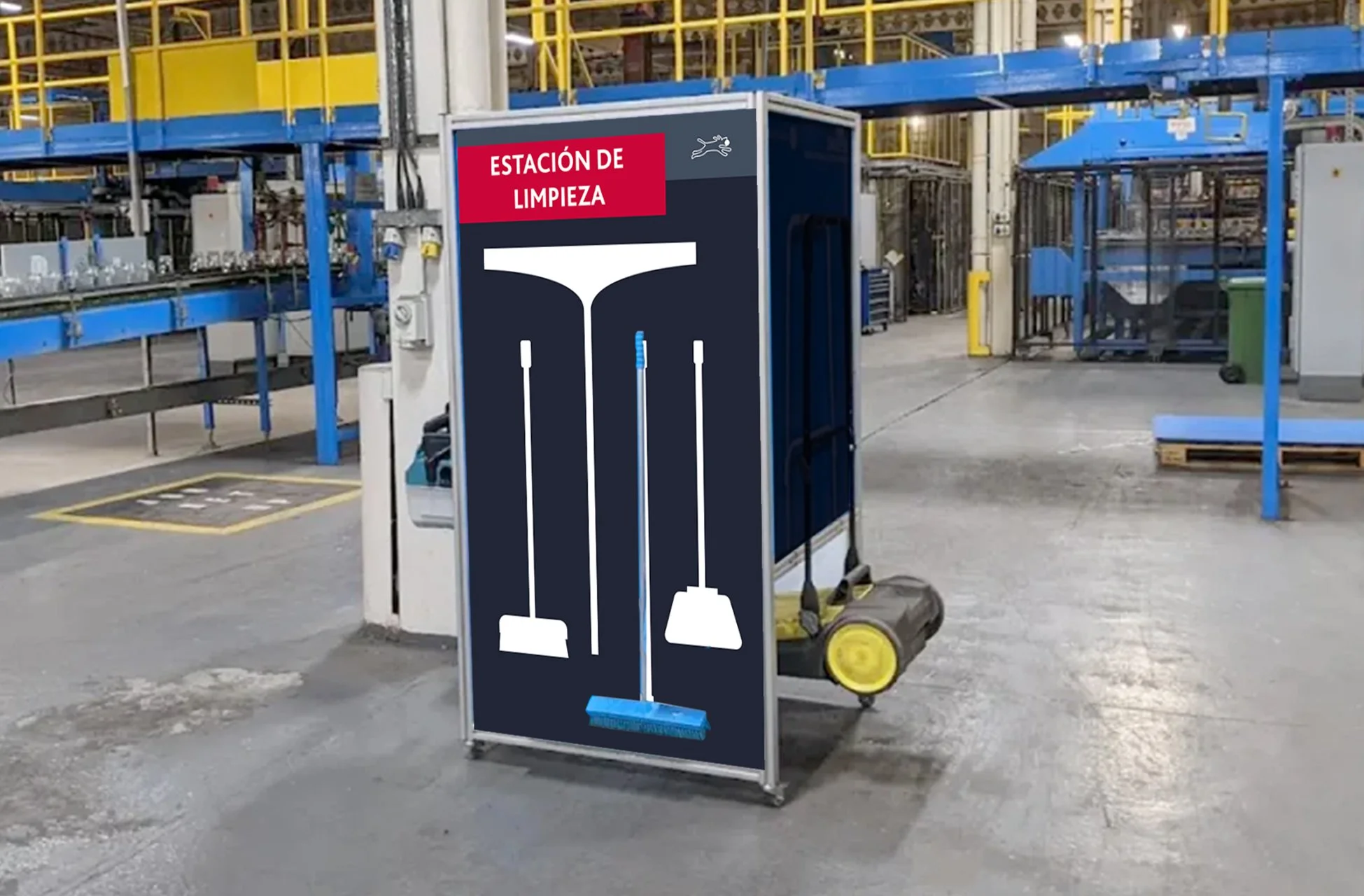 A cleaning station sign in a warehouse with illustrations of a mop, broom, and dustpan, labeled in Spanish 'Estación de Limpieza'.