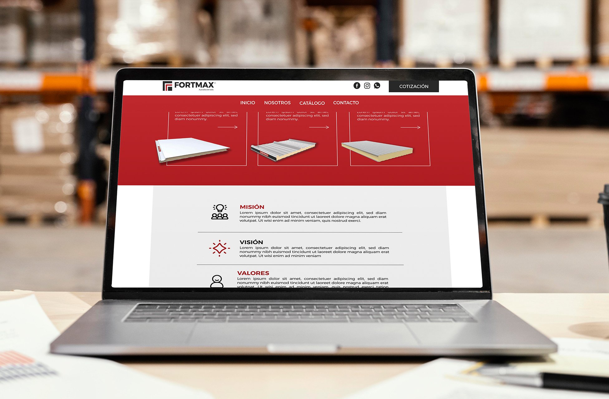 Laptop screen displaying a website for FORTMAX with product images and sections for mission, vision, and values in Spanish, set in a warehouse environment.