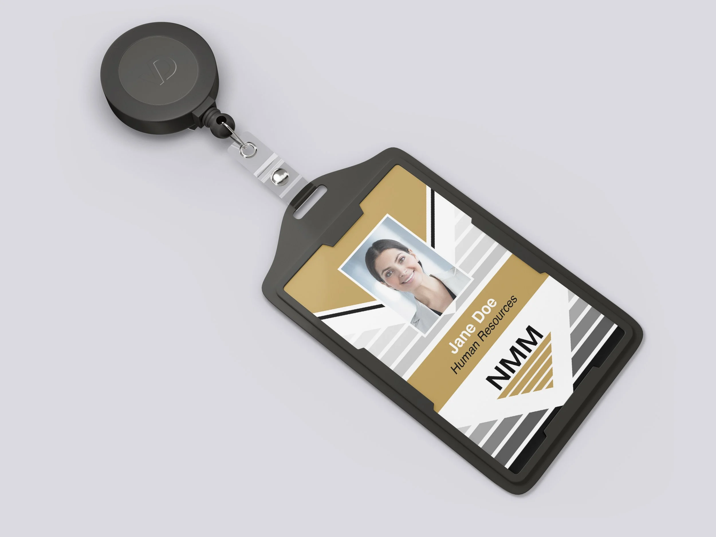 A badge with a photo of a woman, named Jane Doe, labeled as Human Resources, attached to a retractable badge reel on a light-colored surface.
