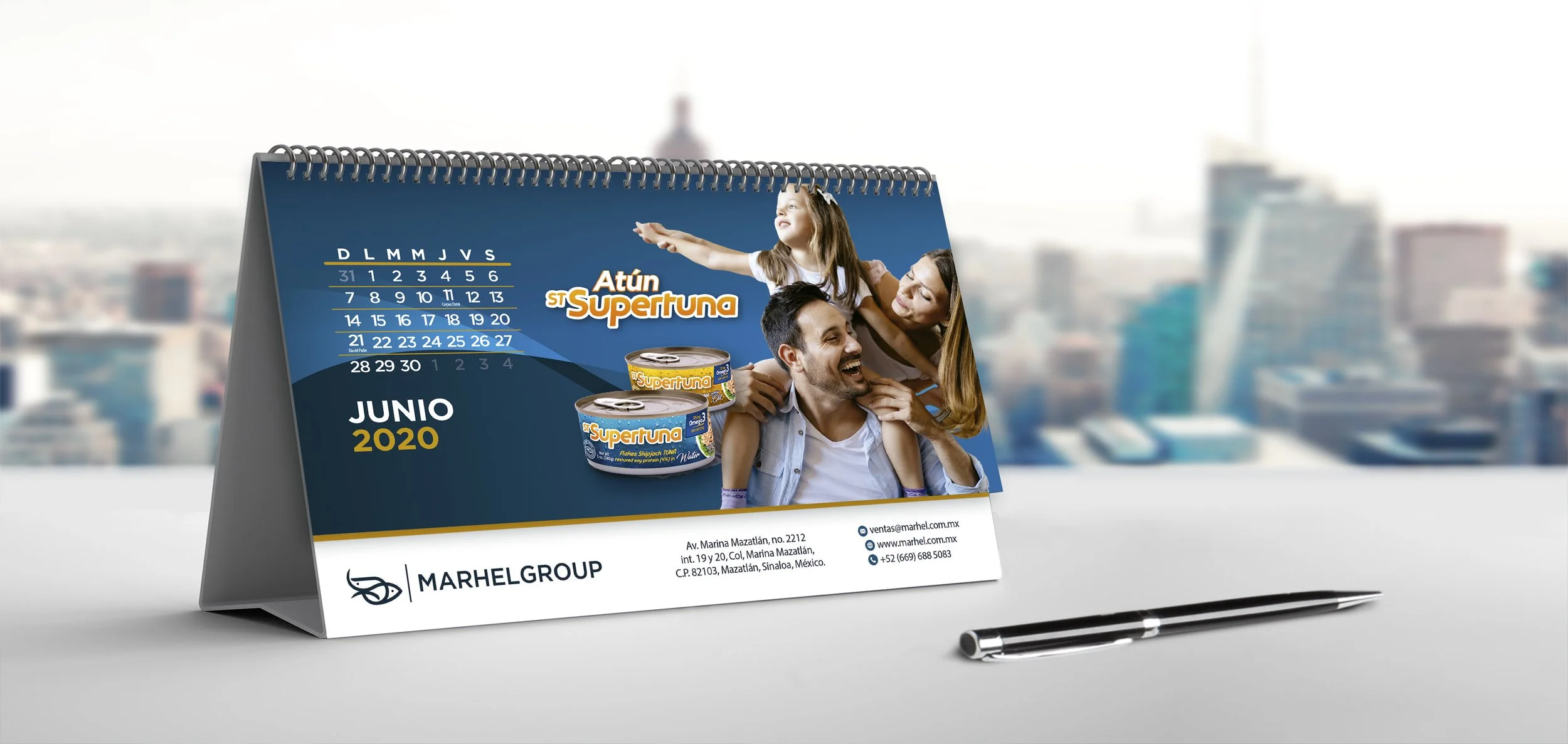 A desk calendar displaying June 2020, with a photo of a family smiling and playing, promotional text for Atún SuperTuna, and contact information at the bottom.