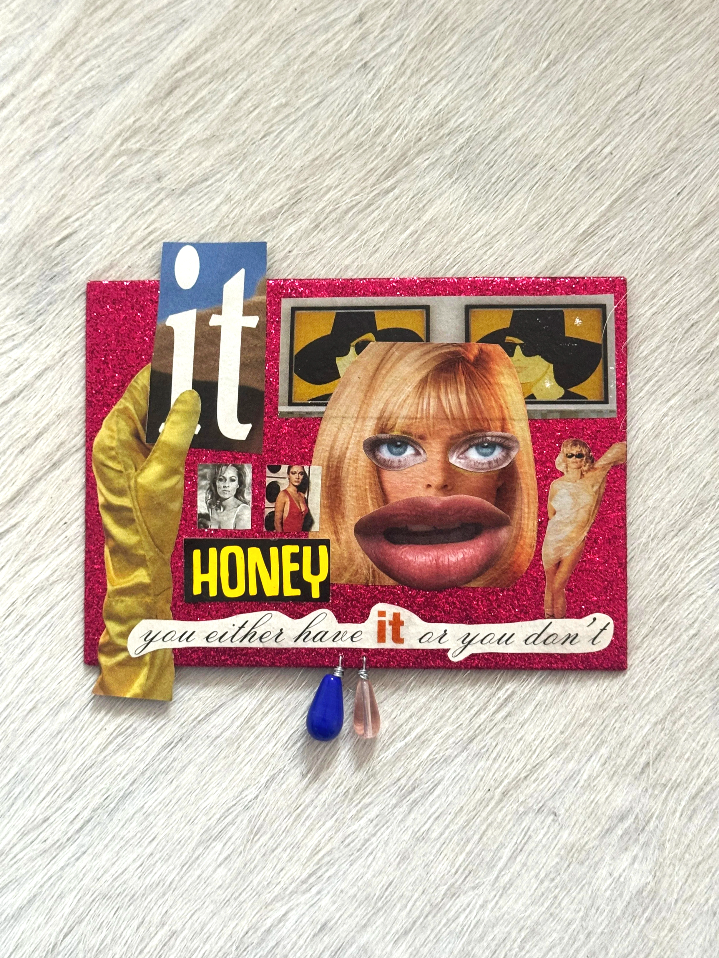 A decorated clipboard with a collage of images, a large face with lips and eyes, and bold text saying 'HONEY.' There is a blue and pink pen hanging from the bottom and yellow gloves on the sides.