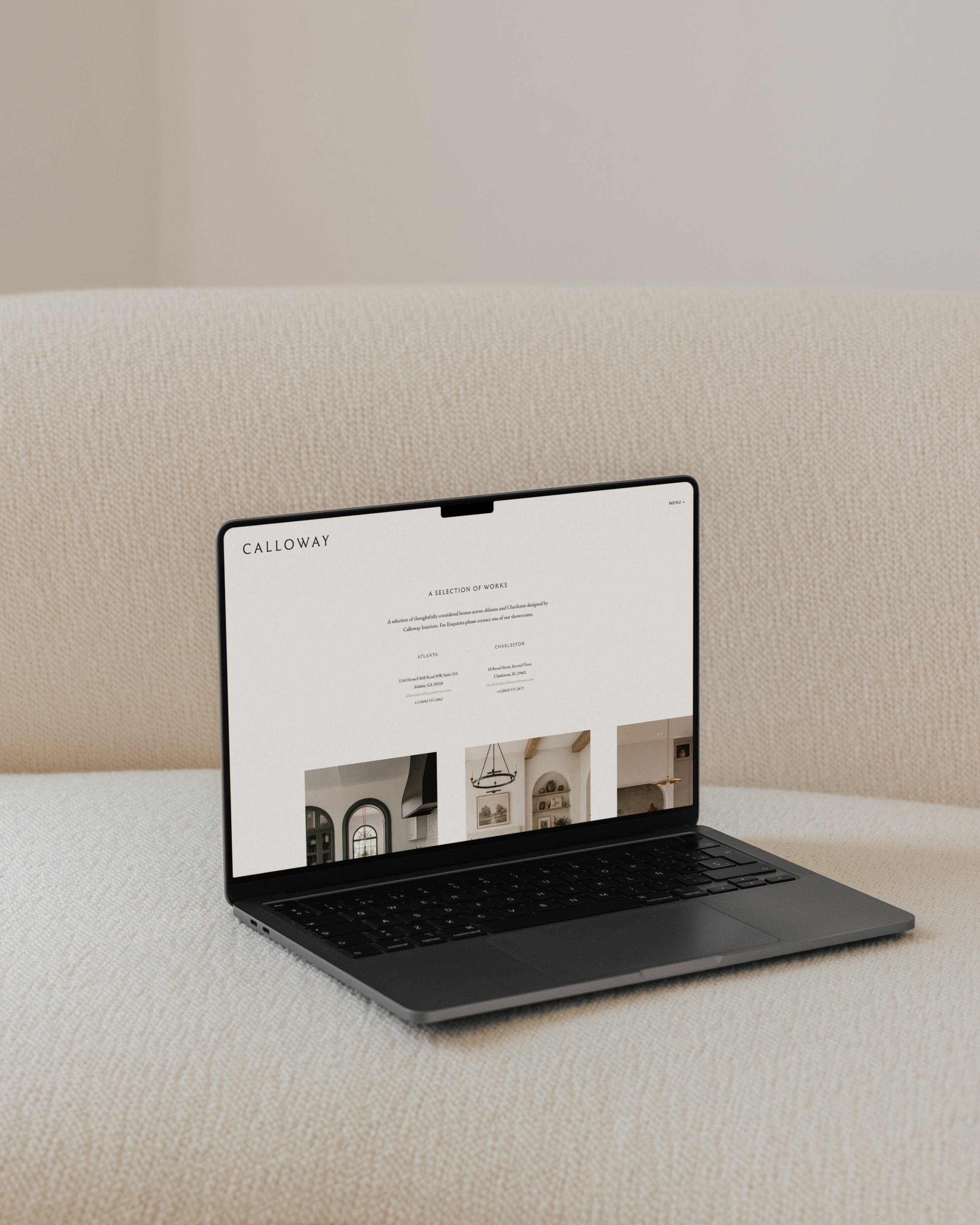 Open laptop on a textured beige surface displaying a website for Calloway with interior photos of a home.