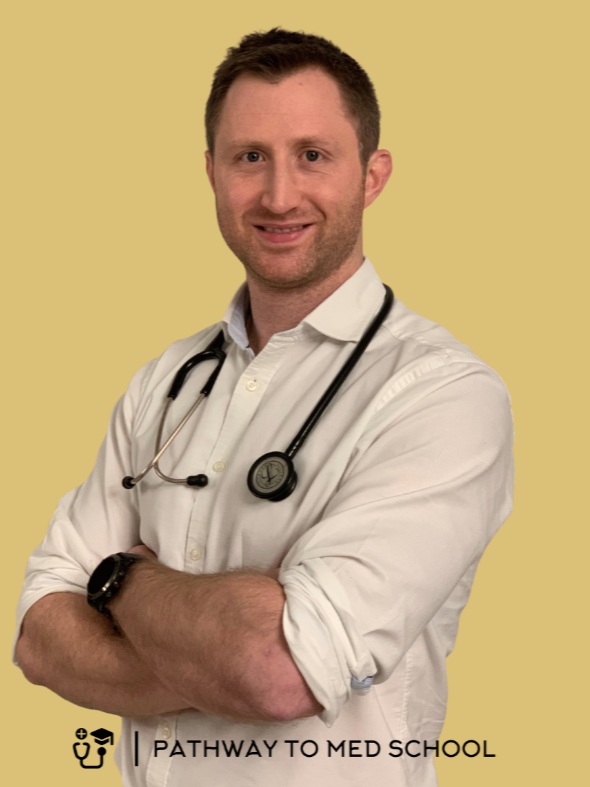 A male doctor in a white coat with a stethoscope around his neck, smiling with arms crossed, standing against a beige background with the text "Pathway to Med School."