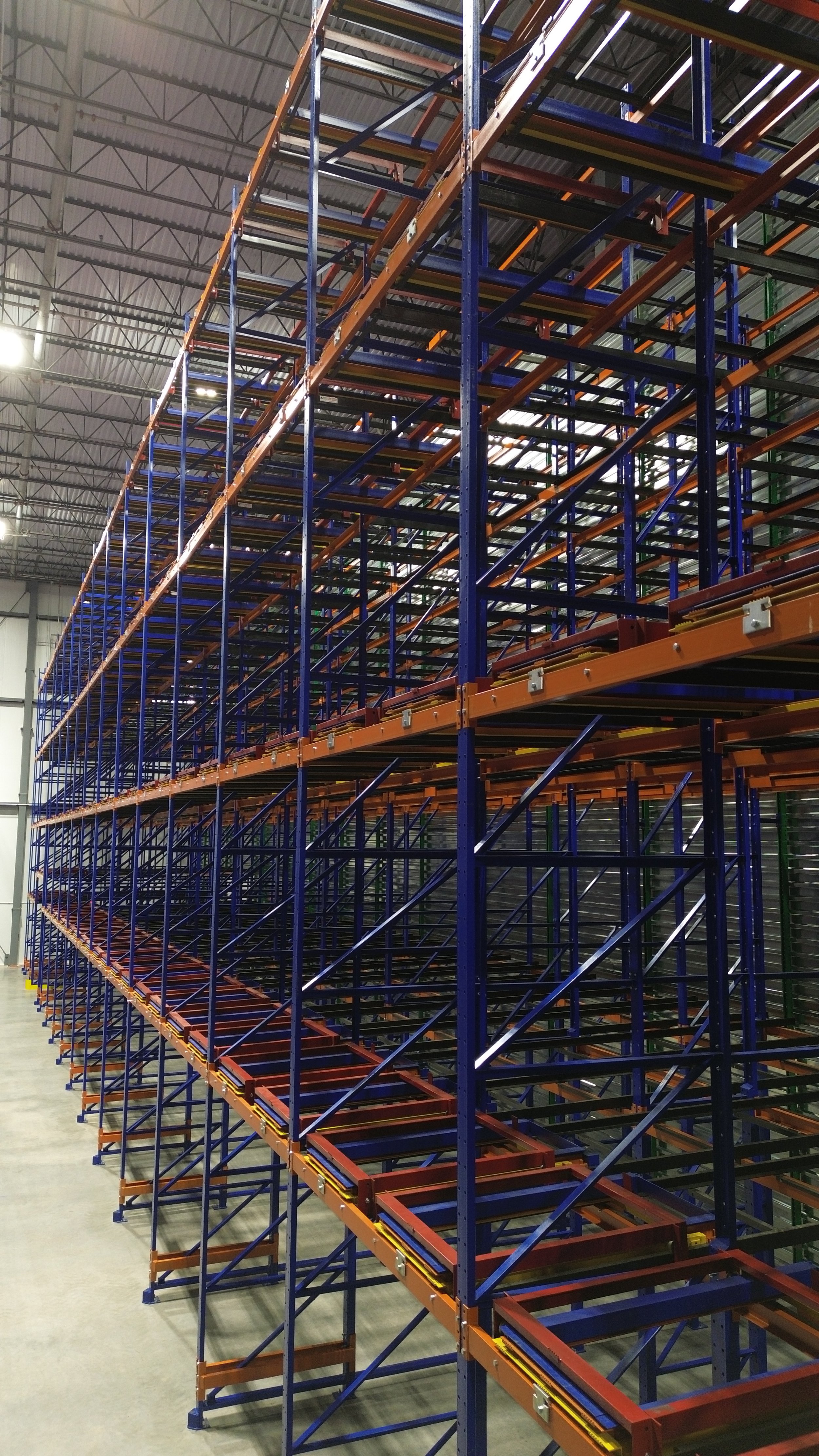 Tall empty warehouse storage racks with multiple levels in a warehouse.