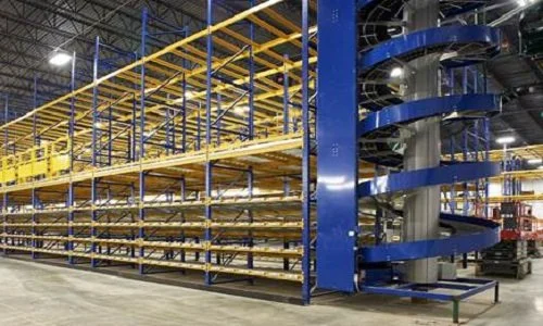Empty industrial warehouse storage shelves with a blue spiral conveyor system on the right.