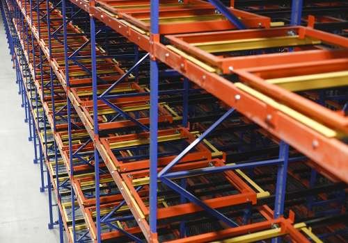 Empty orange and yellow pushback warehouse storage shelves.