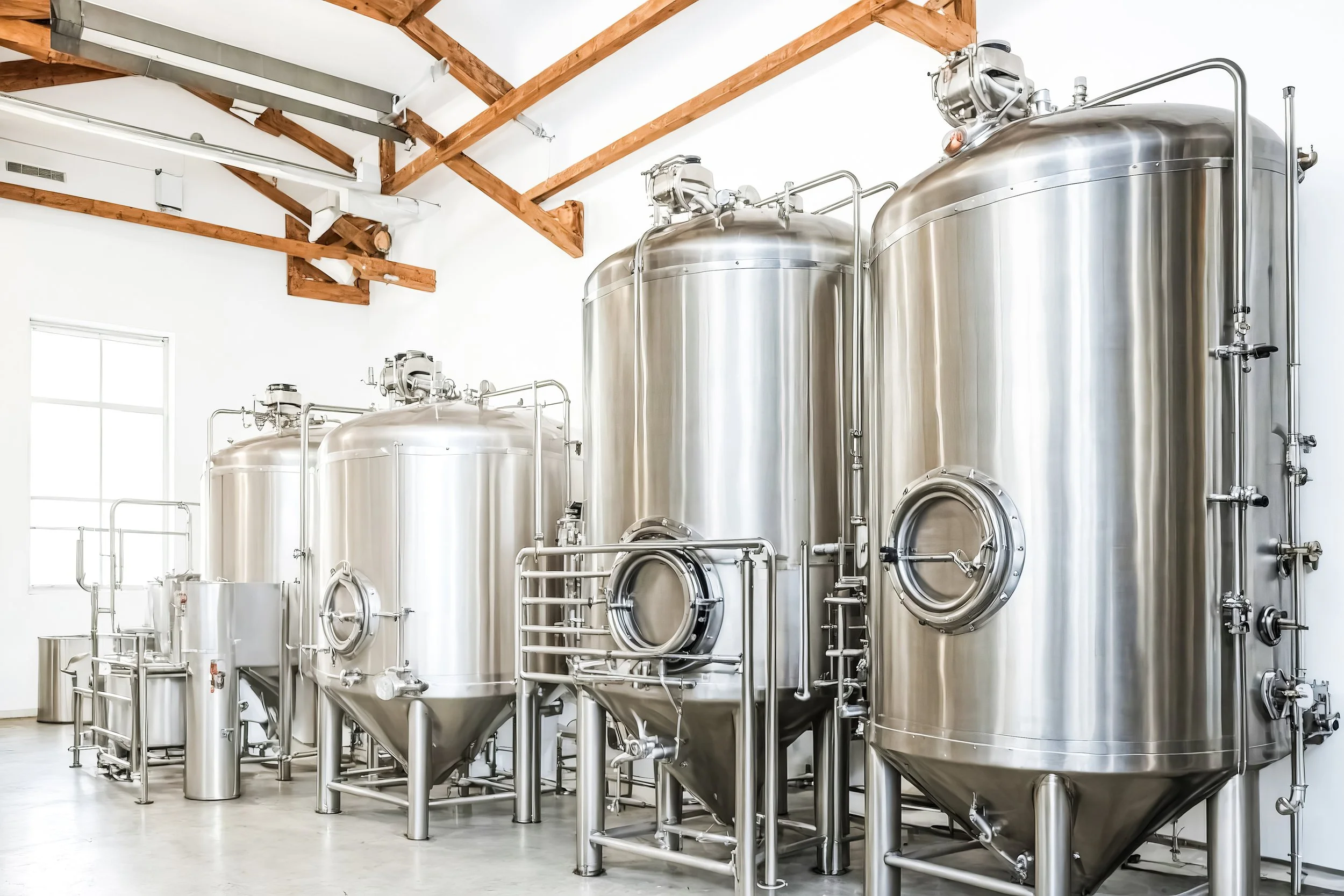 Industrial stainless steel fermentation tanks inside a clean, modern facility.