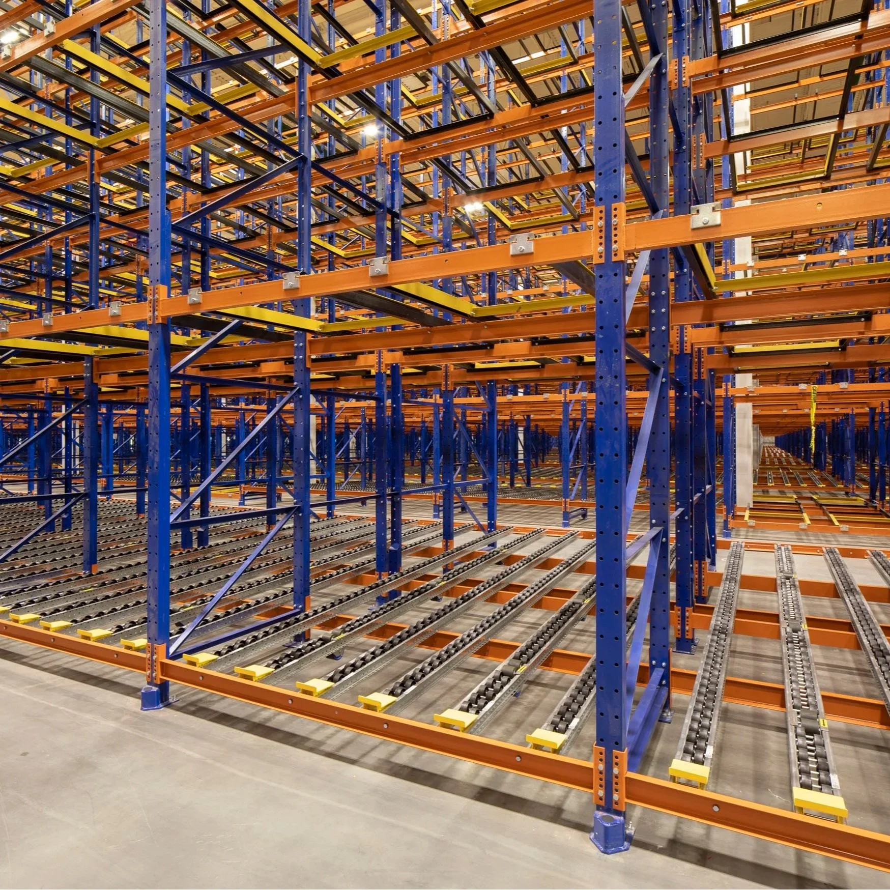 Multiple levels of orange and blue pallet flow racking.