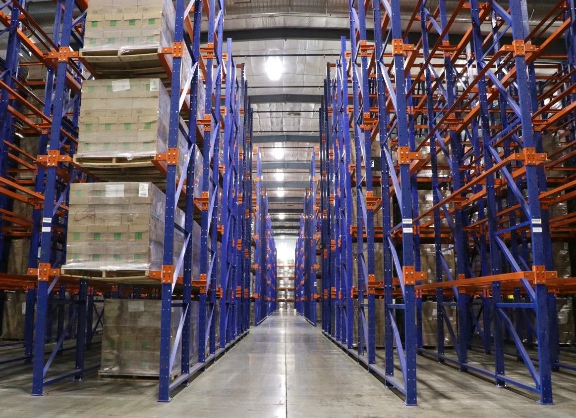 Long warehouse aisle between drive-in racking.
