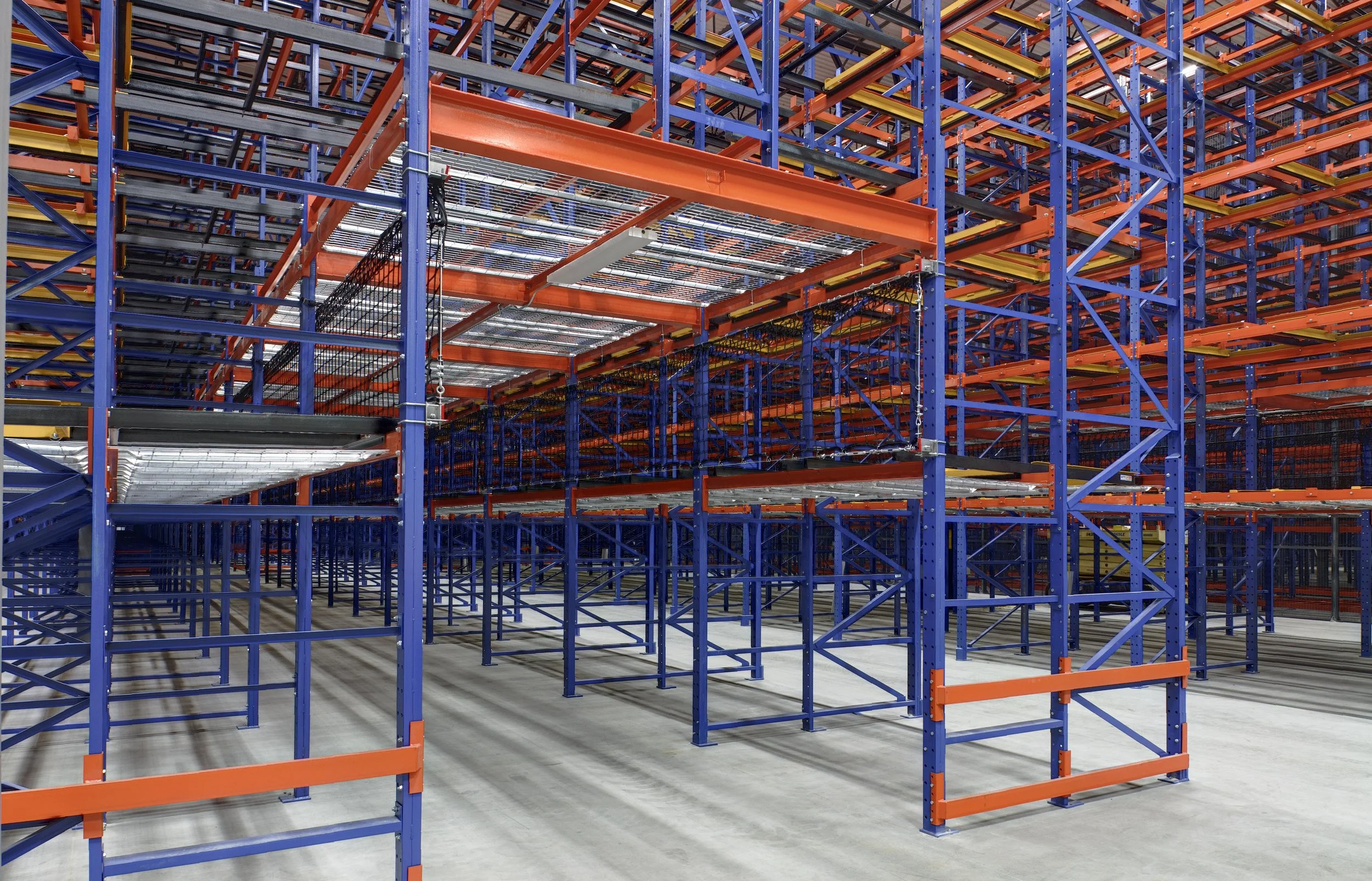 A pick tunnel between metal storage racks and shelves.