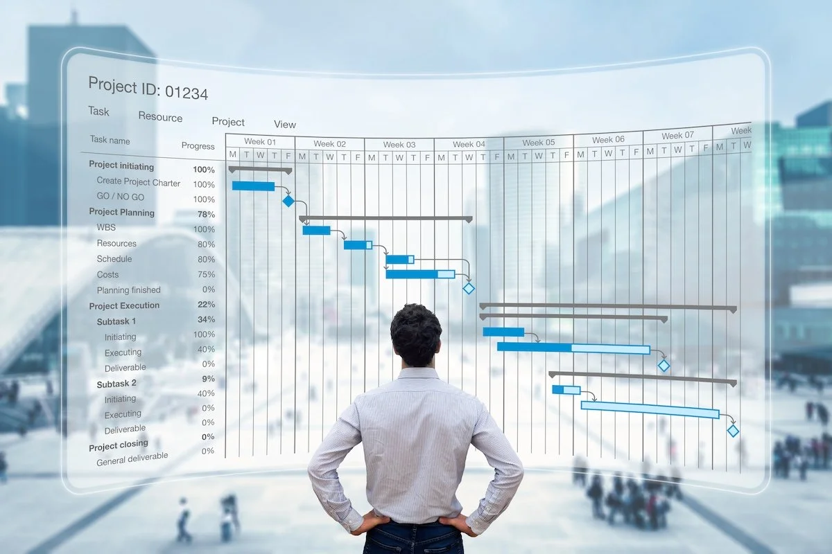 A person looking at a large project management timeline displayed on a transparent screen, with a cityscape background.