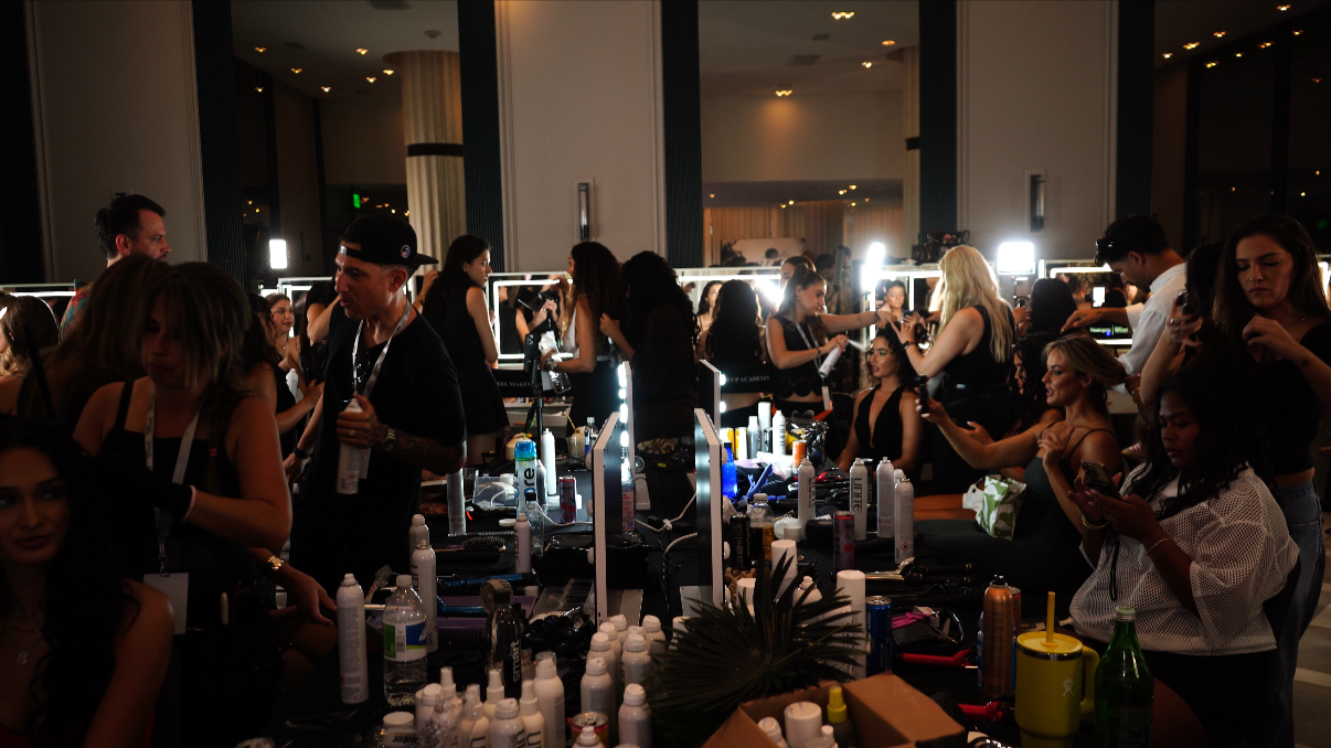 People working at makeup stations backstage at a Miami Swim Week: The Shows