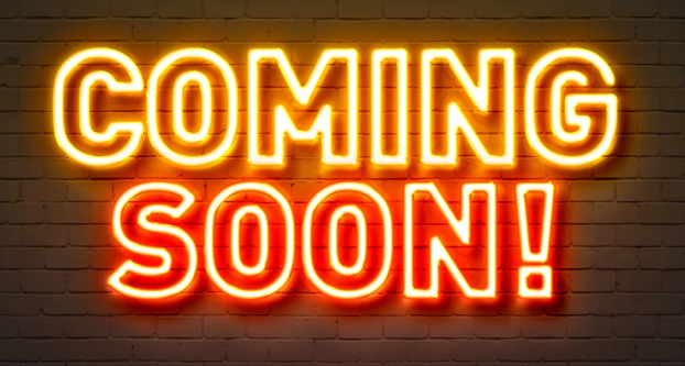 Neon sign on brick wall that says 'COMING SOON!' with 'COMING' in yellow and 'SOON!' in red.
